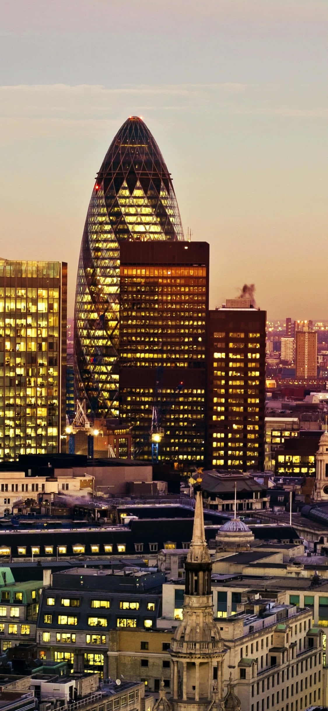 Skyscraper 桌布 壁紙 — 倫敦天際線的壯麗日落景觀，標誌性的小黃瓜摩天大樓散發著溫暖的室內燈光。