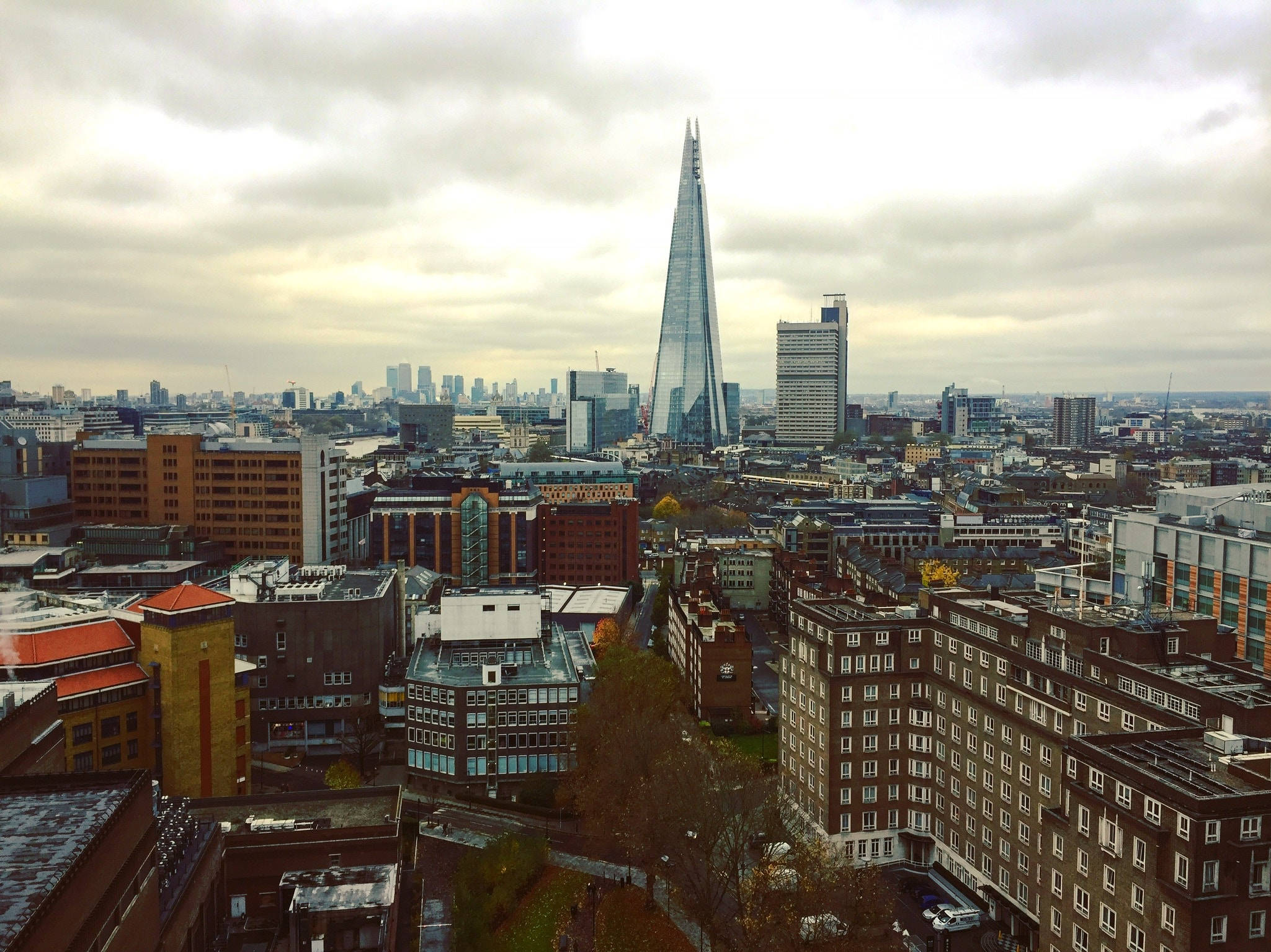 United Kingdom 桌布 壁紙 — 倫敦天際線的陰天景觀，由標誌性的碎片大廈摩天大樓主導，聳立在密集的城市景觀之上。
