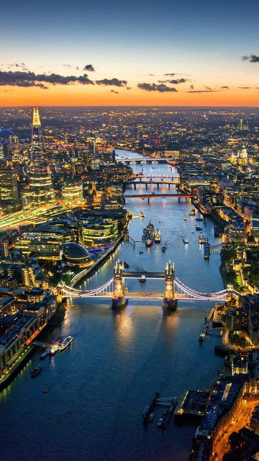 London iPhone 桌布 壁紙 — 倫敦日落時分的鳥瞰圖，塔橋亮燈，泰晤士河倒映城市燈光。