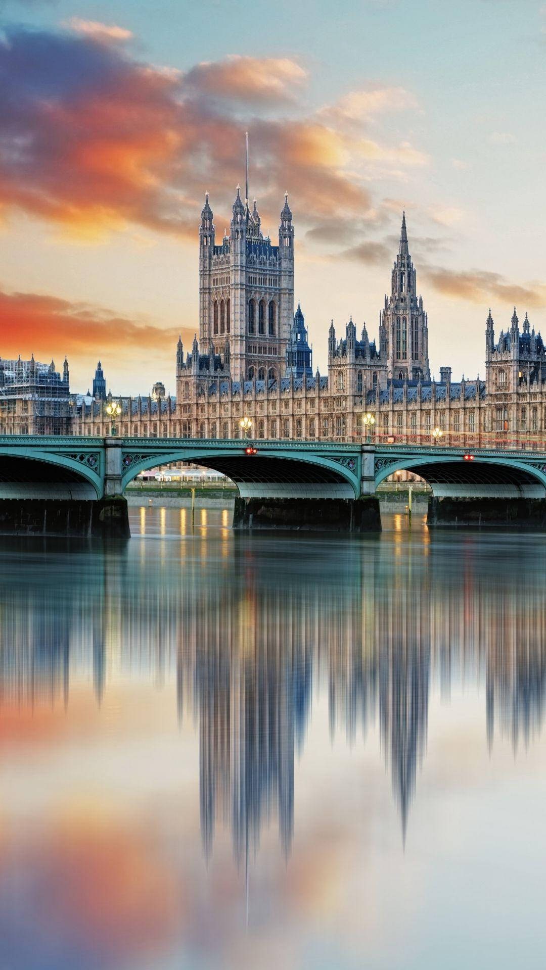 England 桌布 壁紙 — 倫敦標誌性的西敏宮和西敏橋在日落時分寧靜的泰晤士河上美麗地倒映。