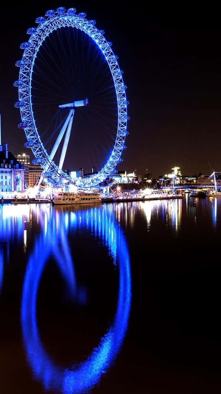 England 桌布 壁紙 — 倫敦眼在夜間發出電藍色光芒，完美倒映在下方黑暗的河面上。