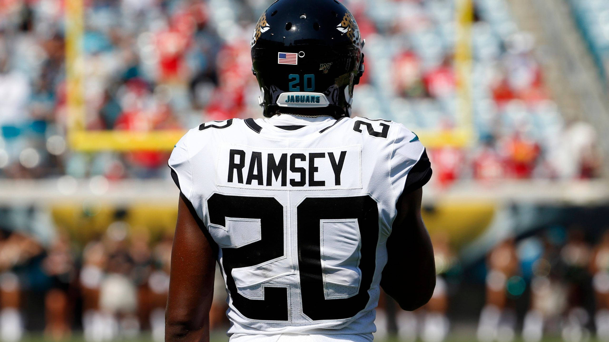 Ramsey 桌布 壁紙 — 傑克遜維爾美洲虎隊球員拉姆齊的背面，身穿白色20號球衣，在陽光明媚的足球場上，背景是模糊的體育場人群。