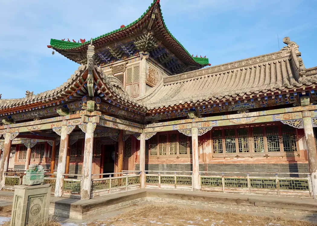 Mongolia 桌布 壁紙 — 傳統中國寺廟，擁有華麗的綠色瓦片屋頂和風化的木柱，在清澈的藍天下。