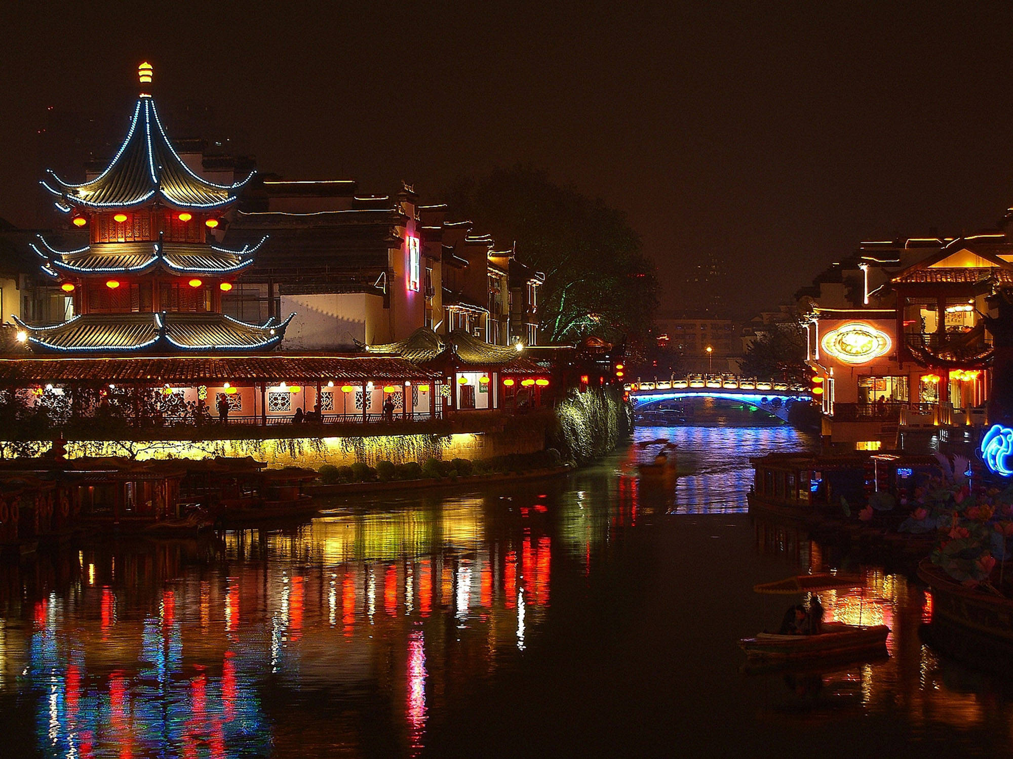 Nanjing 桌布 壁紙 — 傳統中國水鄉的充滿活力的夜景，閃爍的燈籠和色彩繽紛的倒影在運河上舞動。