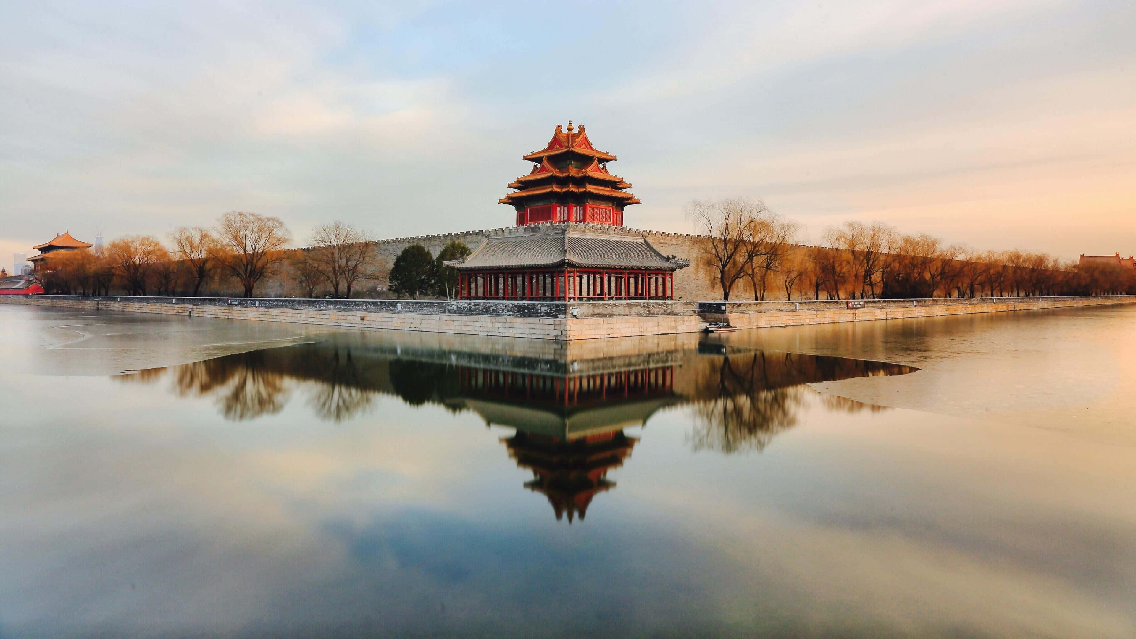 reflection 桌布 壁紙 — 傳統中式宮殿塔樓，紅牆金頂，在黃金時刻完美倒映在平靜的水面上。