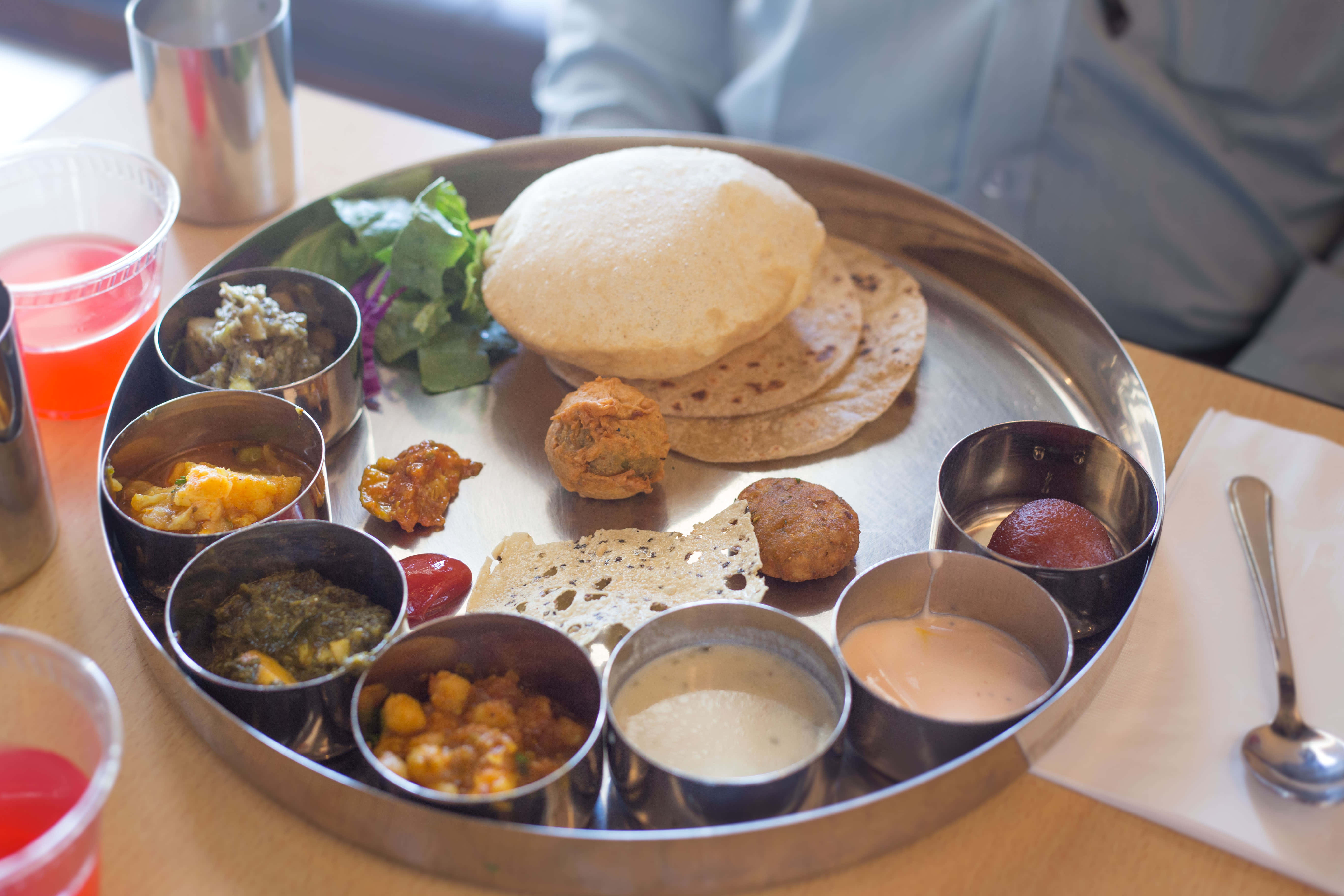 Thali 桌布 壁紙 — 傳統印度塔利餐，盛載於圓形金屬盤上，有多個小碗盛載色彩繽紛的咖哩、烤餅和酸辣醬。