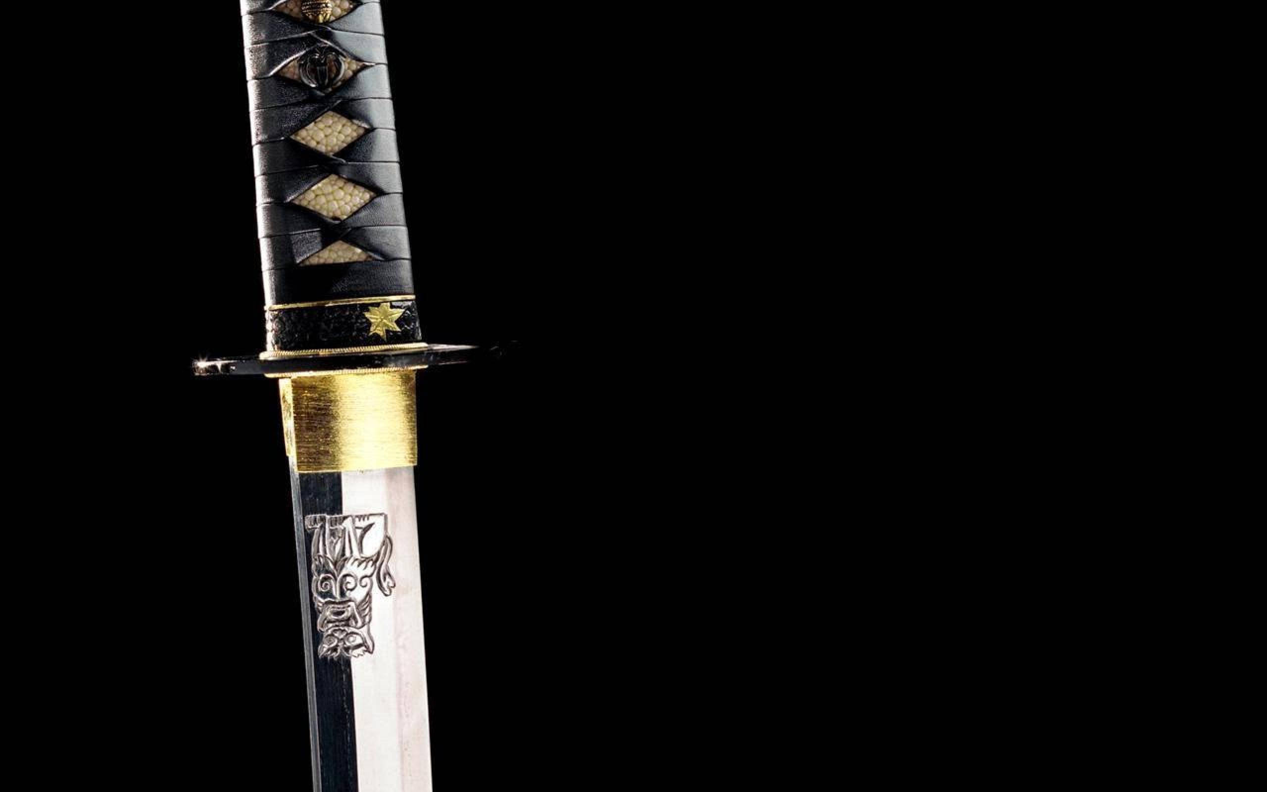 Kill Bill 桌布 壁紙 — 傳統日本刀的近距離特寫，黑色刀柄搭配金色裝飾，背景為純黑色。