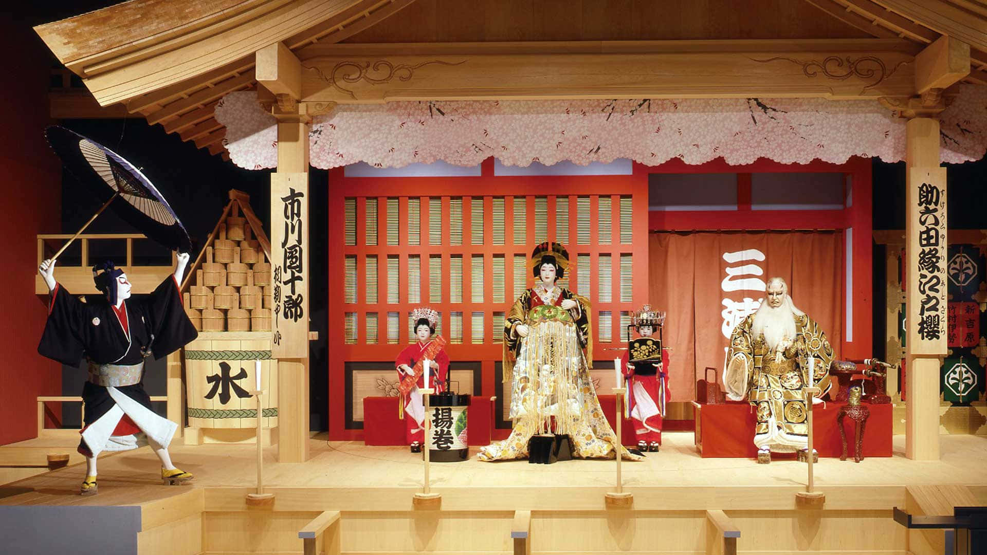 Tokugawa 桌布 壁紙 — 傳統日本能劇人偶擺放在木製舞台上，配有櫻花和紅色屏風。