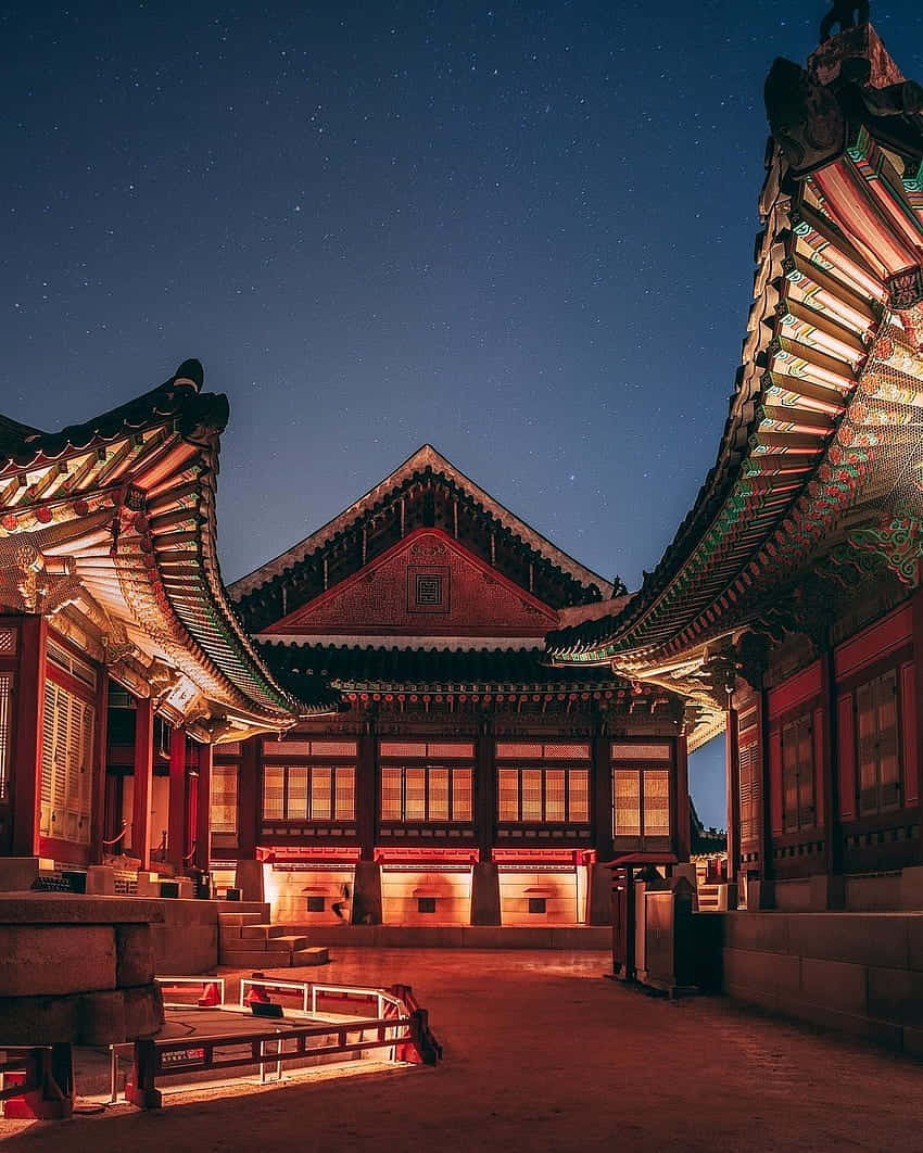 韓國 桌布 壁紙 — 傳統韓國宮殿建築在星空下溫暖發光，屋頂細節精緻。