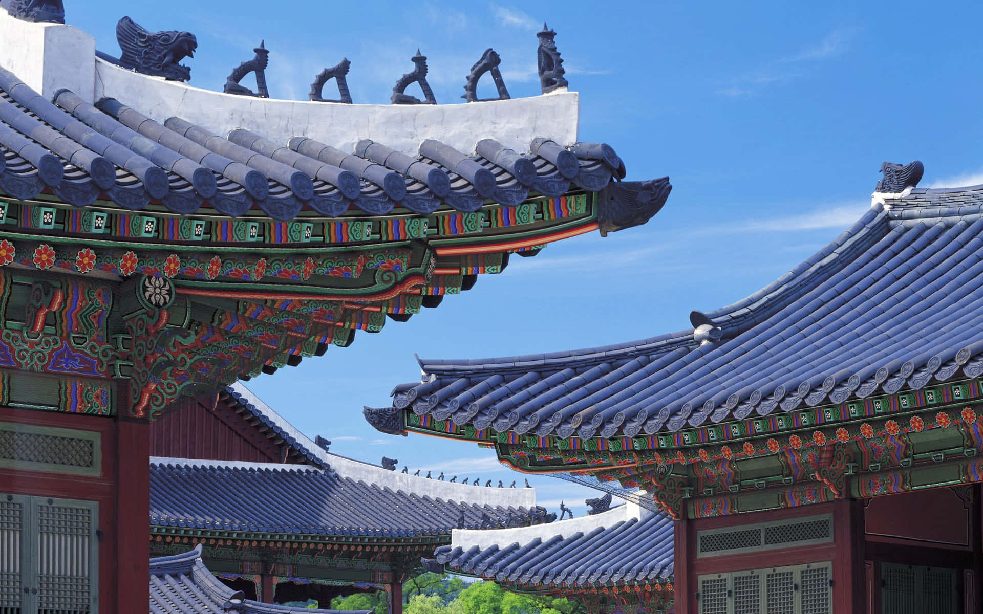 Architecture 桌布 壁紙 — 傳統韓國寺廟屋頂，帶有彎曲的藍色瓦片和鮮豔彩繪的屋簷，在清澈的藍天下。