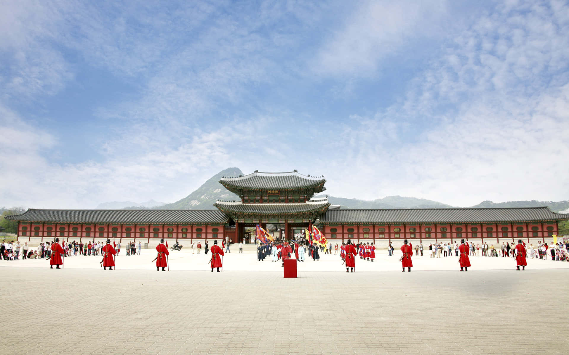Architecture 桌布 壁紙 — 傳統韓國衛兵身穿紅色制服，在藍天白雲下雄偉的宮殿前立正站崗。