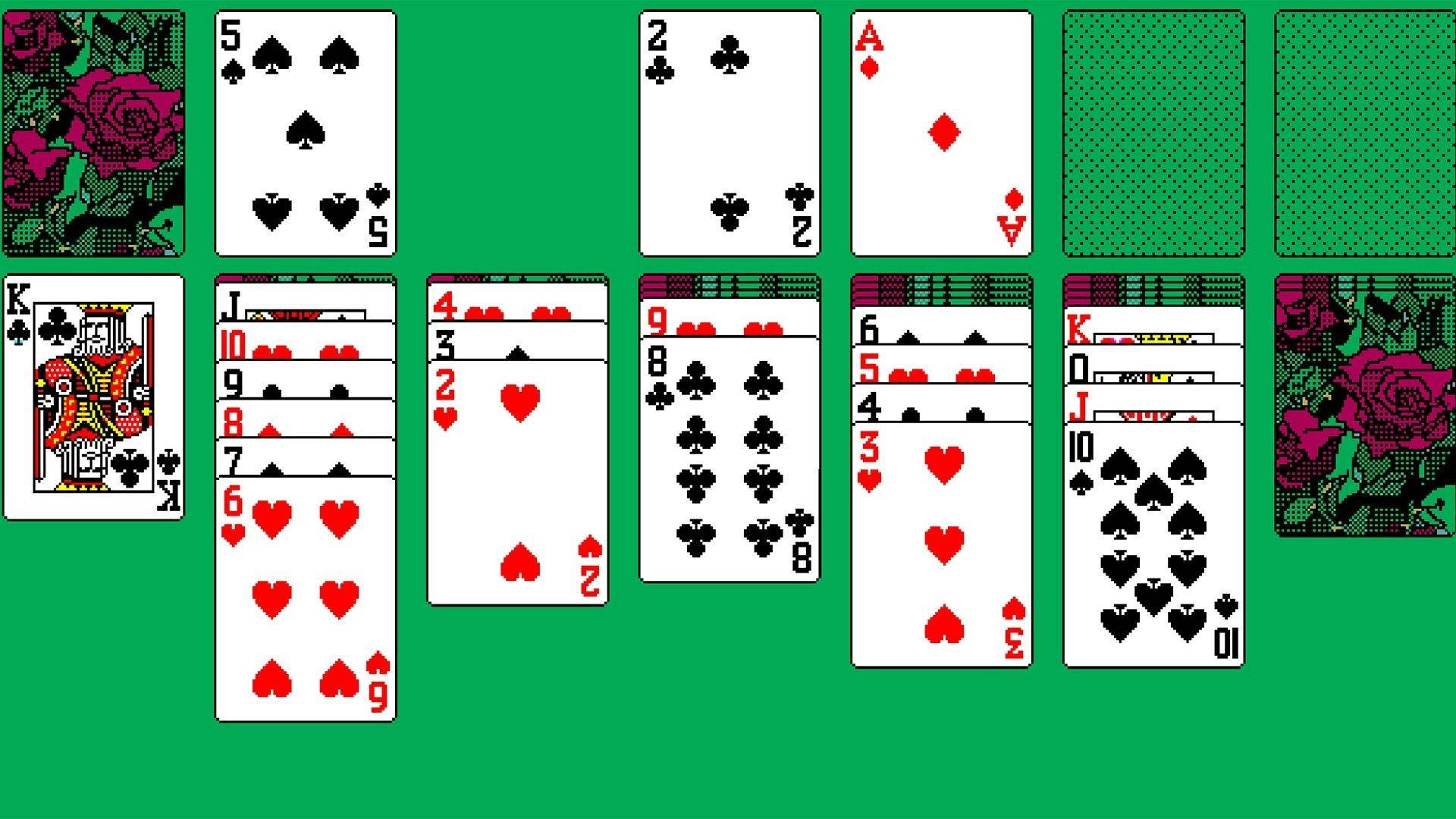 Solitaire 桌布 壁紙 — 像素化的撲克牌以接龍佈局排列在充滿活力的綠色絨氈背景上，背面有玫瑰圖案的撲克牌。