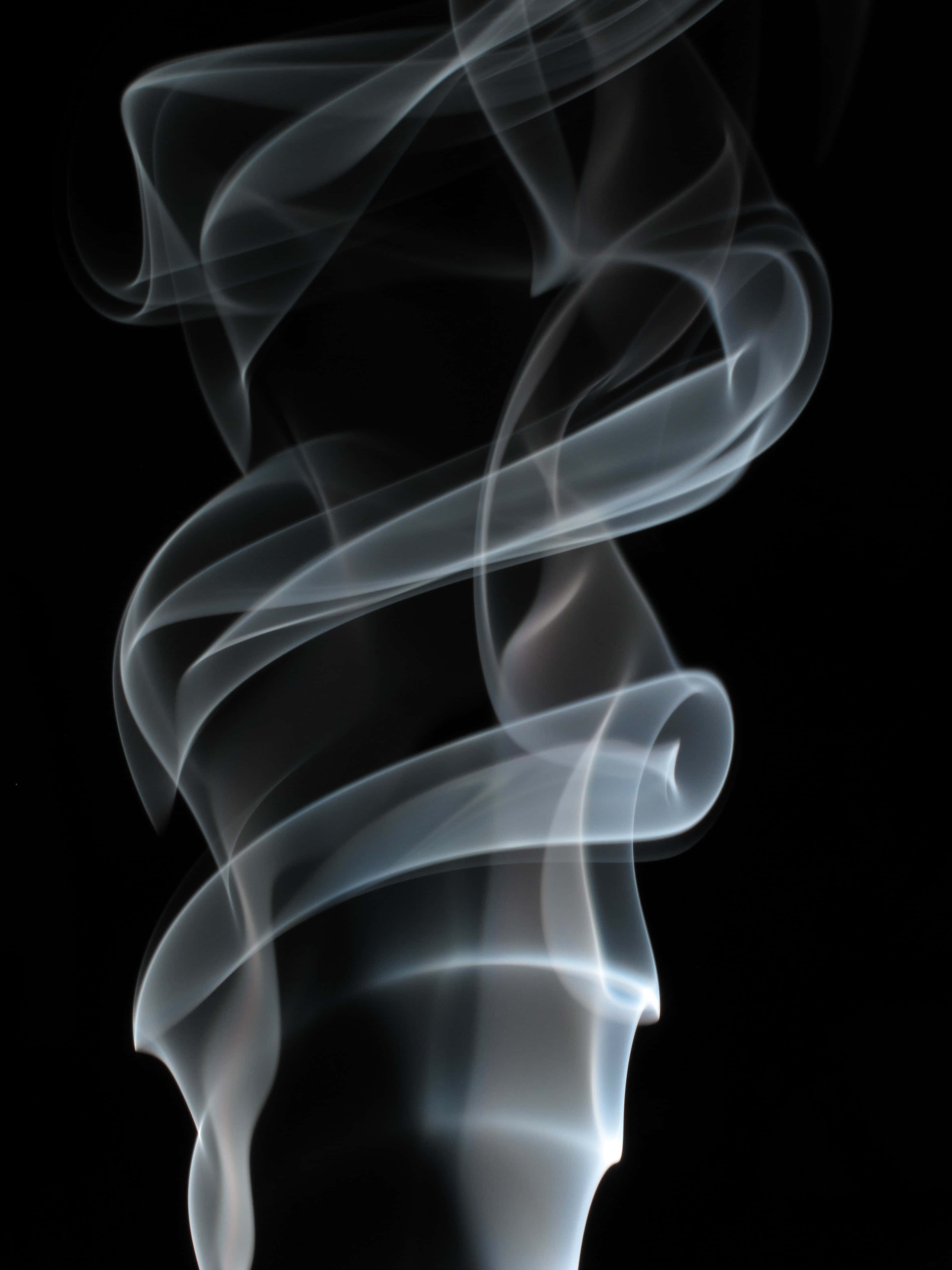 Smokey 桌布 壁紙 — 優雅旋轉的煙霧以柔和白色和灰色在純黑背景上升起，營造出寧靜的抽象形態。
