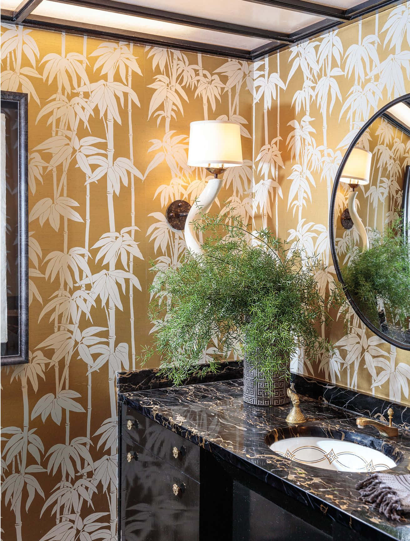 Bathroom Decor 桌布 壁紙 — 優雅浴室，配金色竹紋壁紙、黑色大理石洗手台和弧形鏡子，在溫暖壁燈照明下。