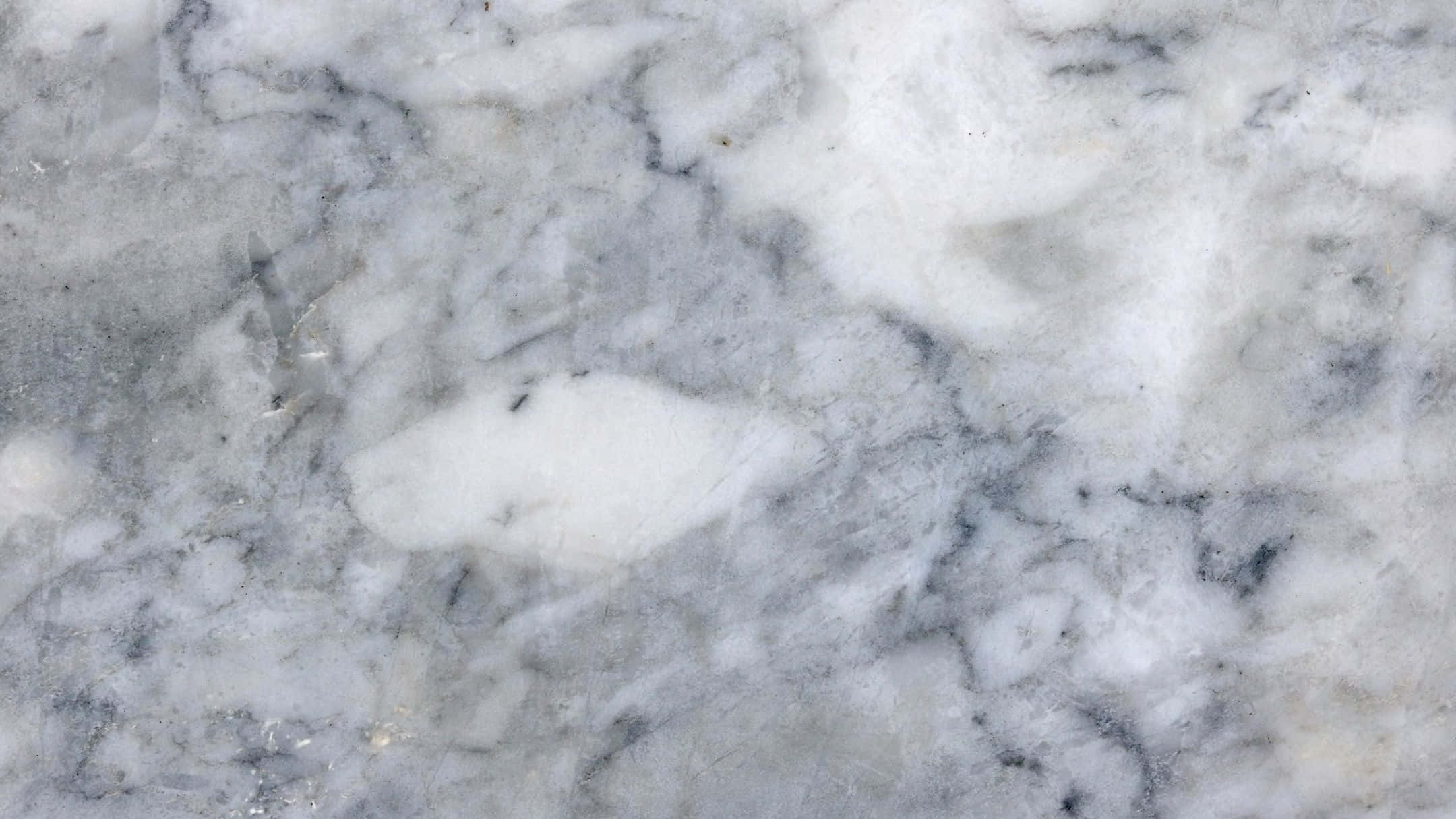 Grey Marble 桌布 壁紙 — 優雅白色大理石的特寫，帶有漩渦狀灰色紋理和細微金色斑點，在柔和光線下。