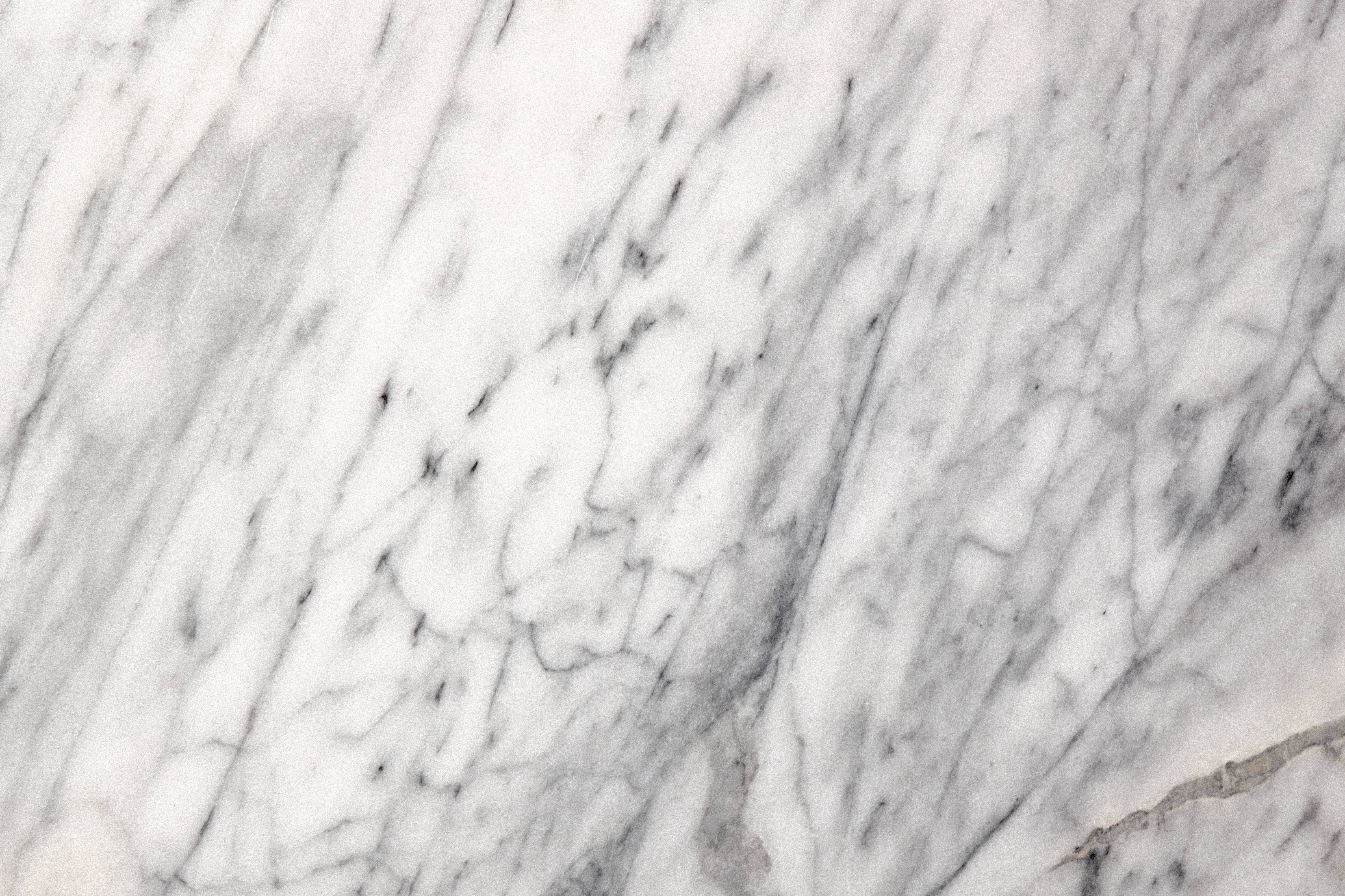 Marble Texture 桌布 壁紙 — 優雅白色大理石的特寫，帶有漩渦狀灰色紋理和細微的自然裂縫。
