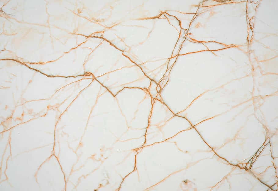 Brown Marble 桌布 壁紙 — 優雅白色大理石的近距離特寫，帶有複雜的金棕色紋理，營造出奢華的自然圖案。