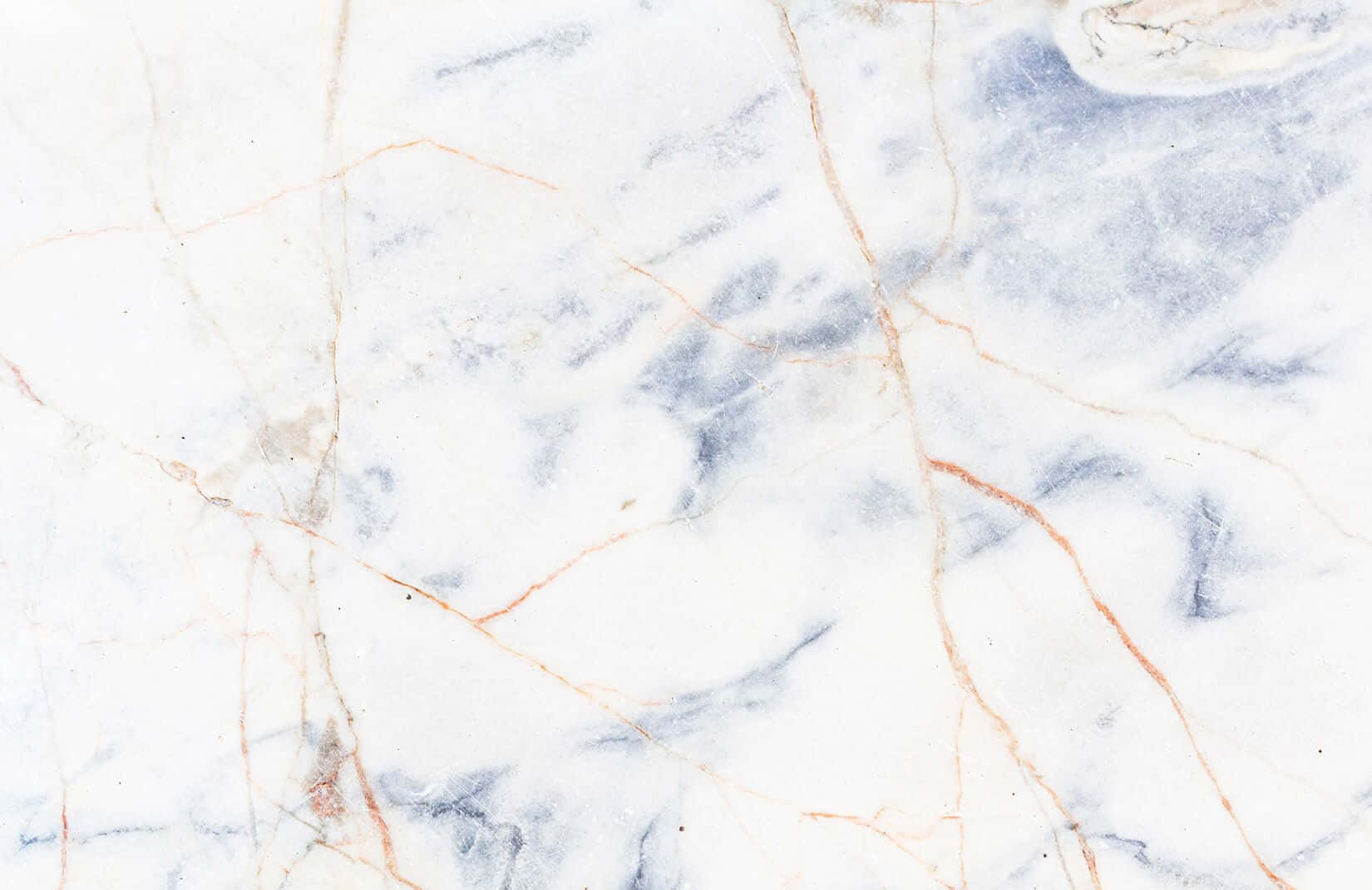 Aesthetic Marble 桌布 壁紙 — 優雅白色大理石的近距離特寫，帶有旋轉的藍色和金色紋理，營造出奢華的自然圖案。