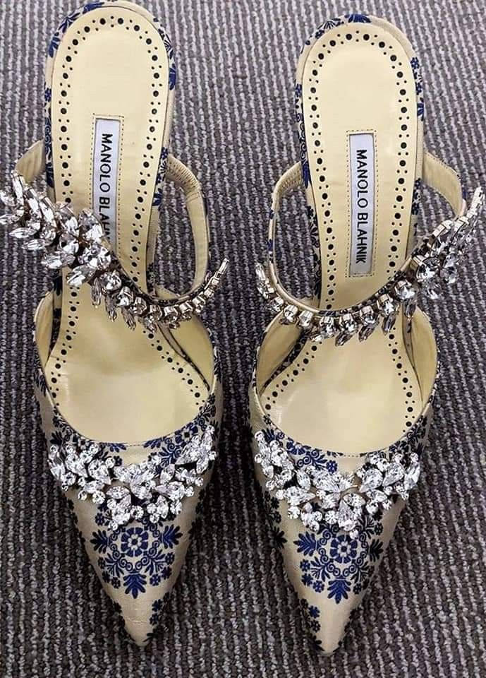 鞋子 桌布 壁紙 — 優雅的 Manolo Blahnik 高跟鞋，帶有藍色花卉圖案和閃閃發光的水晶裝飾，放置在質感灰色地毯上。