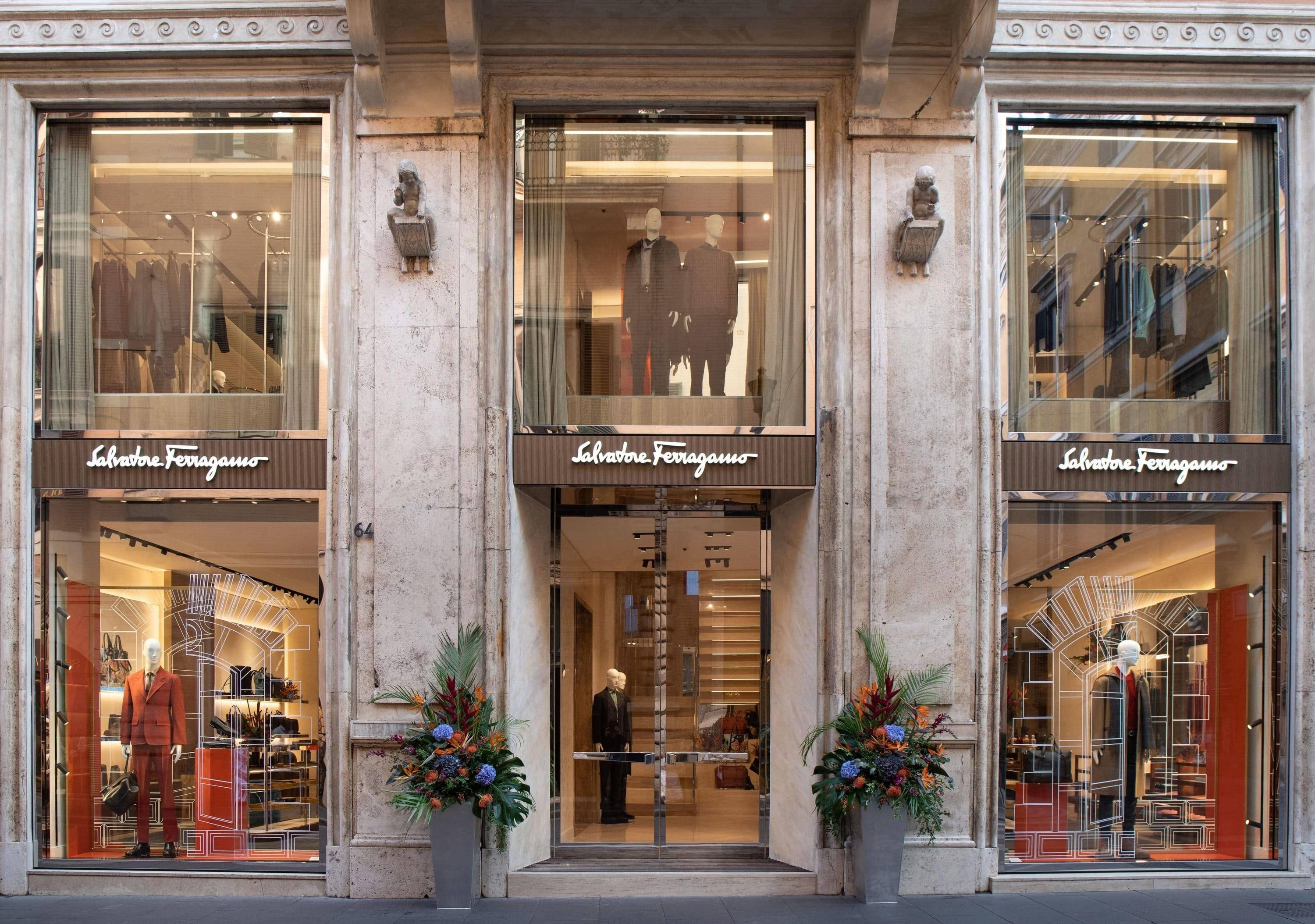 Ferragamo 桌布 壁紙 — 優雅的Salvatore Ferragamo商店外牆，配有大理石柱、玻璃櫥窗和展示奢華男裝的人體模型。