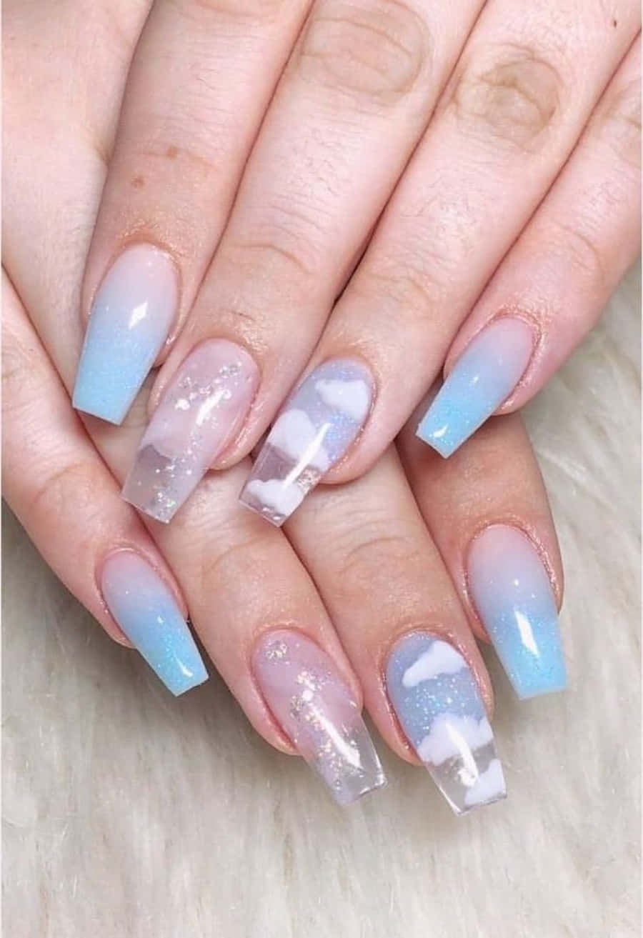 Nail 桌布 壁紙 — 優雅的天空主題指甲，帶有柔和藍色漸變和白色雲朵貼紙，放在毛茸茸的白色表面上。
