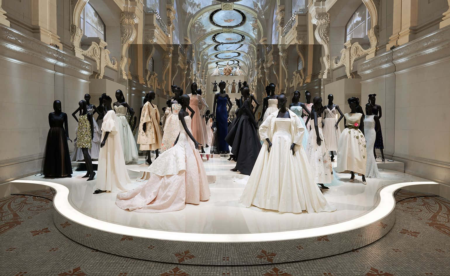 Dior 動態 桌布 壁紙 — 優雅的婚紗陳列在黑色人體模型上，位於宏偉華麗的畫廊中，配有鏡面天花板和大理石地板。