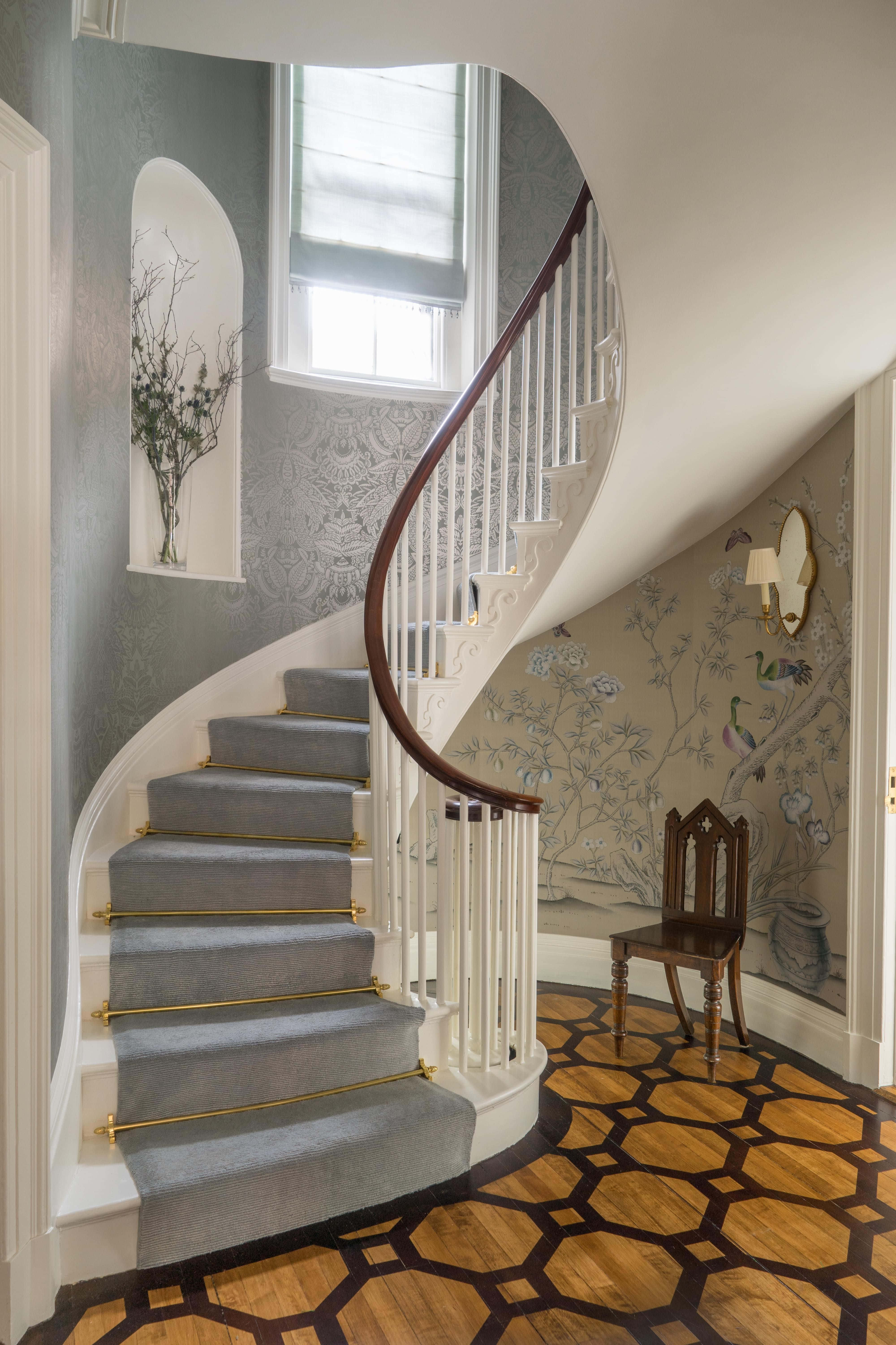 stairs 桌布 壁紙 — 優雅的弧形樓梯，配有灰色地毯和金色扶手，在花卉壁紙和幾何木地板旁邊上升。