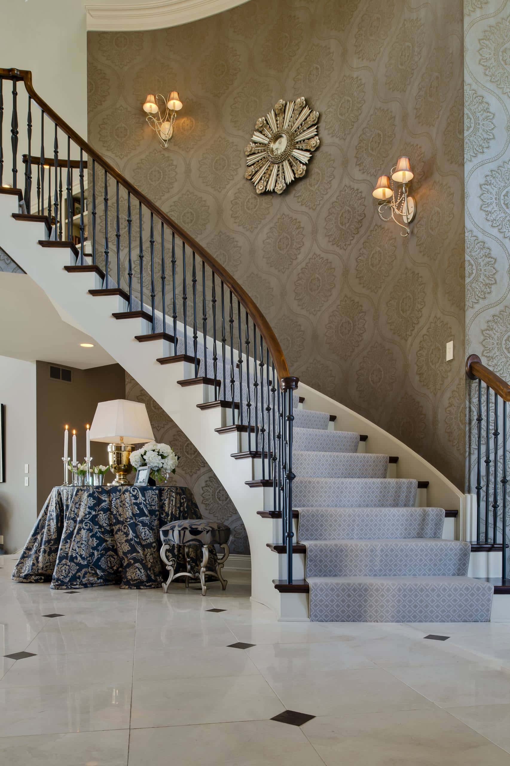 stairs 桌布 壁紙 — 優雅的弧形樓梯，配有華麗壁紙和圖案地毯，穿過豪華門廳，鋪有大理石地板和復古壁燈。