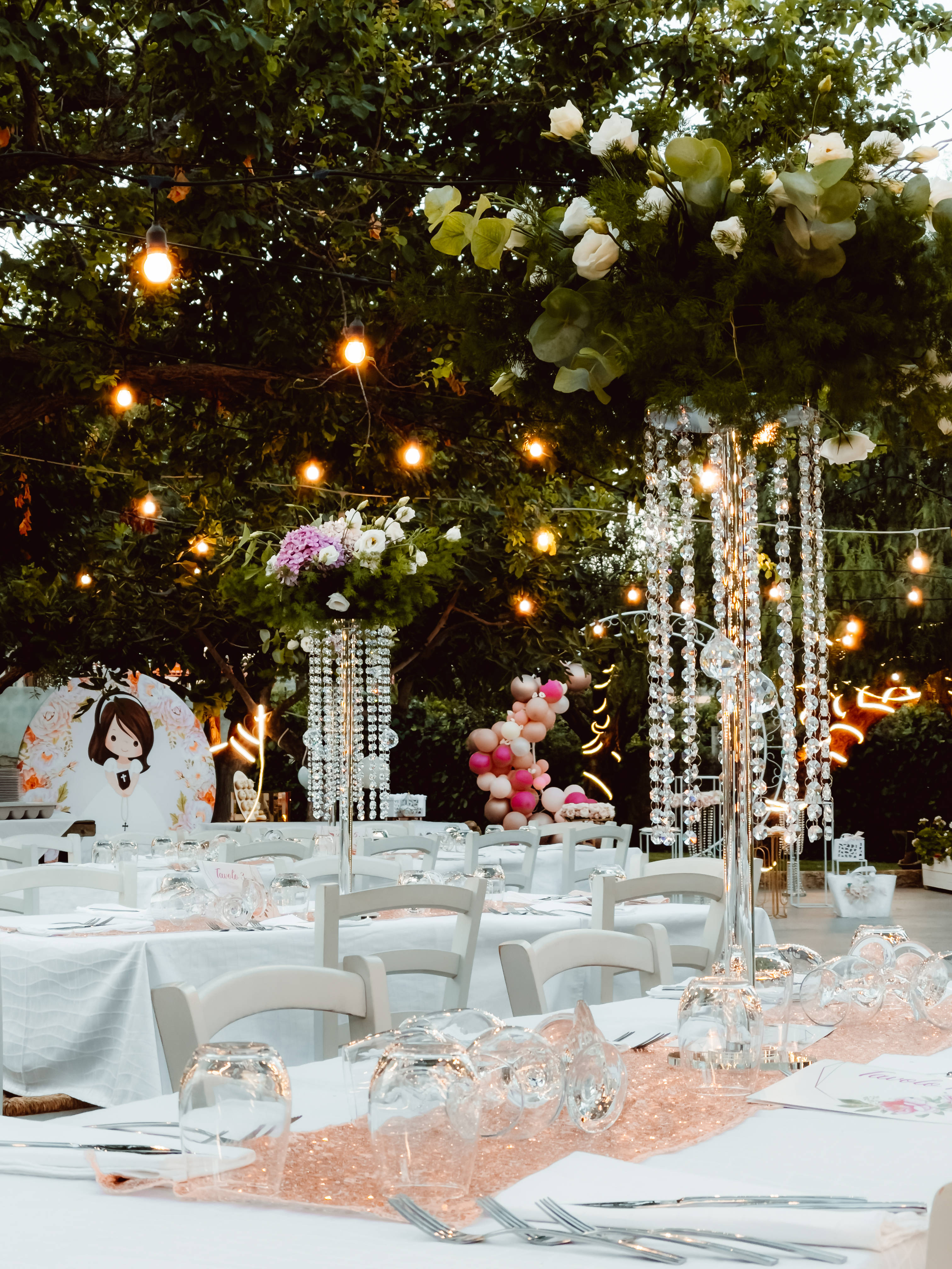 Wedding Aesthetic 桌布 壁紙 — 優雅的戶外婚宴，在串燈下配有花卉中心裝飾和水晶吊燈。