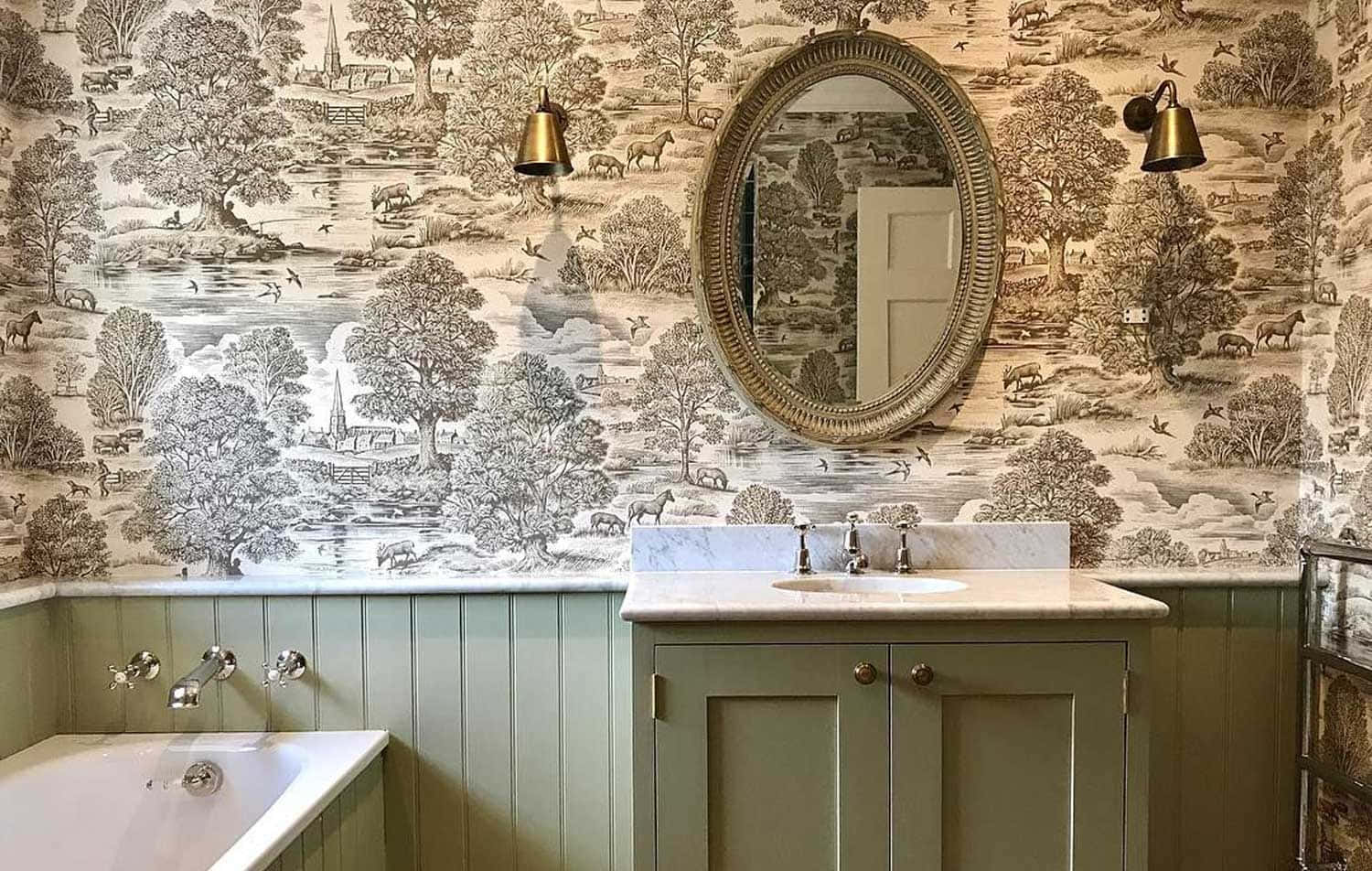 Bathroom Decor 桌布 壁紙 — 優雅的浴室，配有描繪田園風光的托伊爾壁紙，以及華麗壁燈下的復古梳妝台。