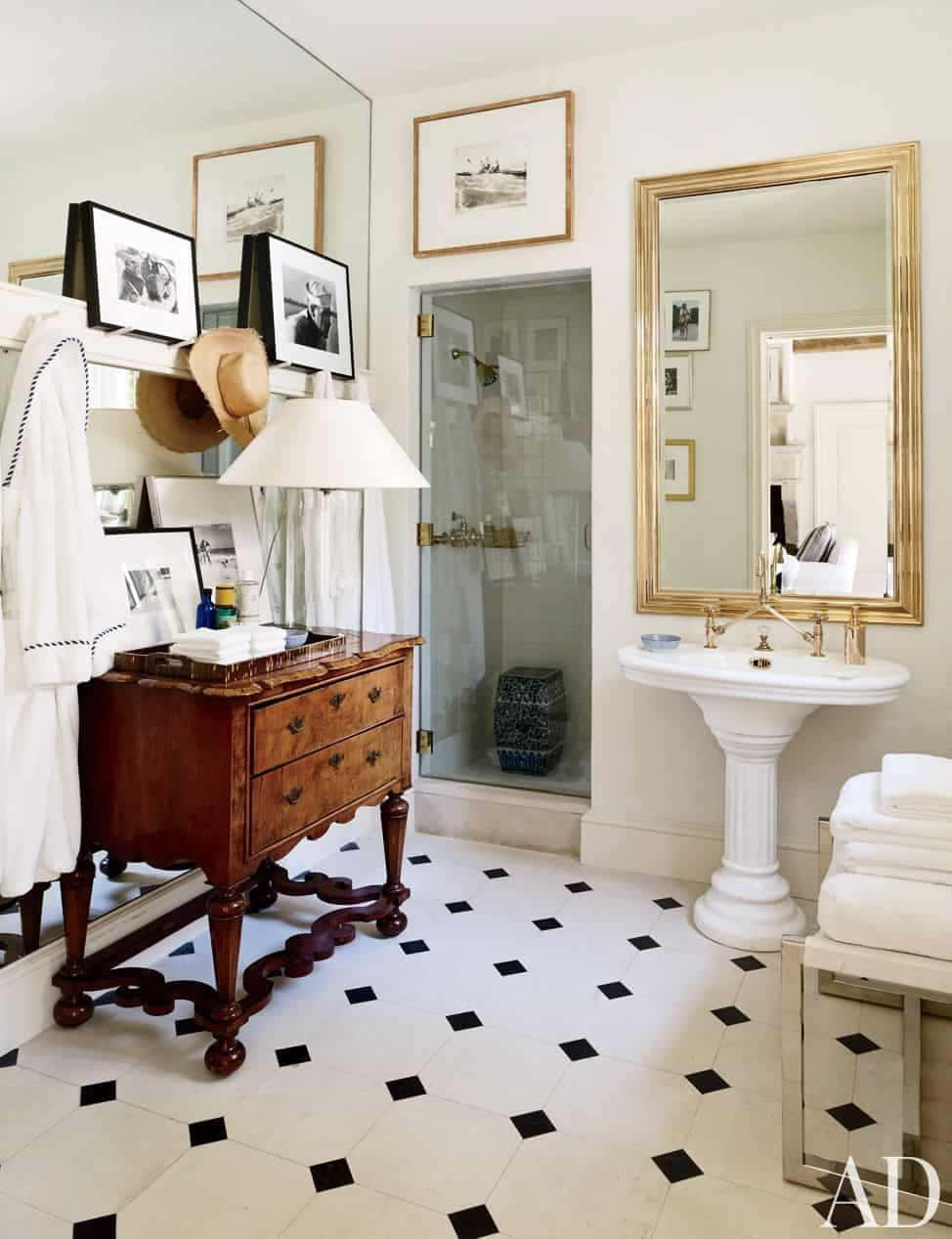 Black And White Bathroom 桌布 壁紙 — 優雅的浴室，配有黑白瓷磚地板、復古木製梳妝台、金色鏡框鏡子和白色立柱洗手盆。