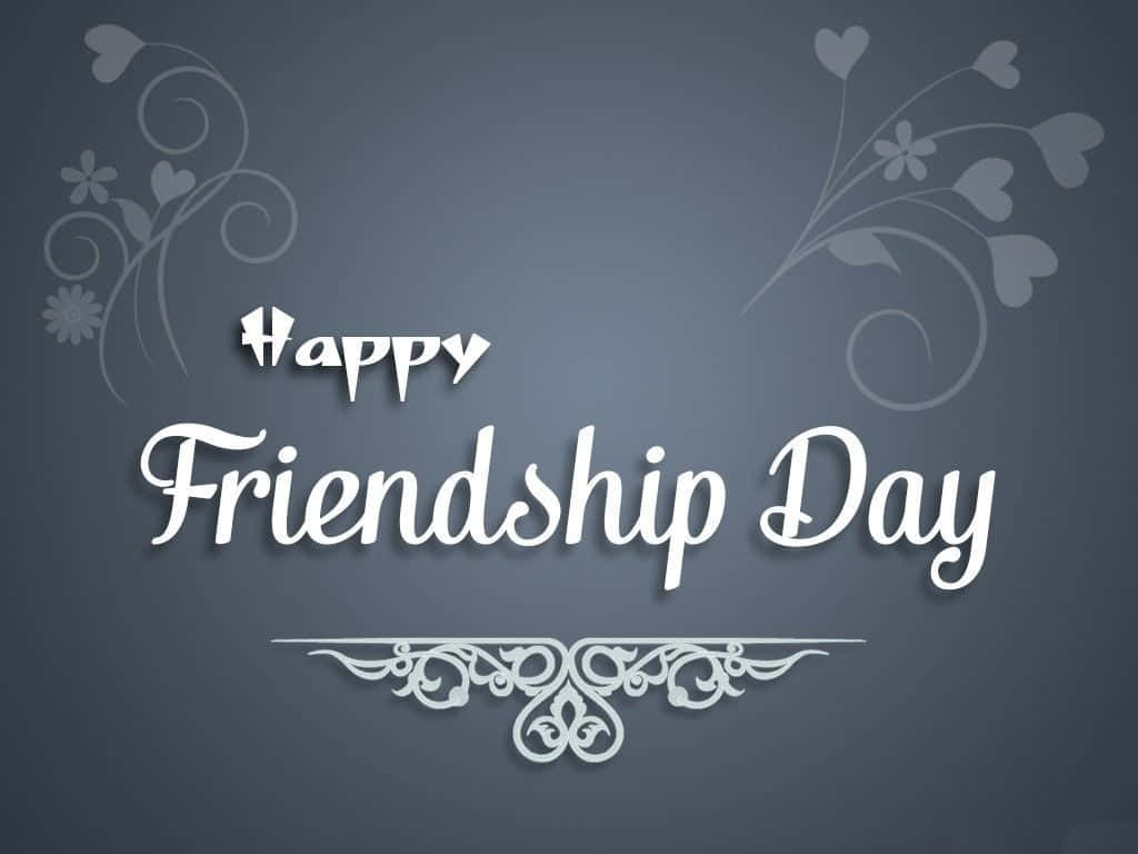 Friendship Day 桌布 壁紙 — 優雅的白色字體在深灰色背景上寫著「Happy Friendship Day」，背景點綴著精緻的花卉漩渦和心形圖案。
