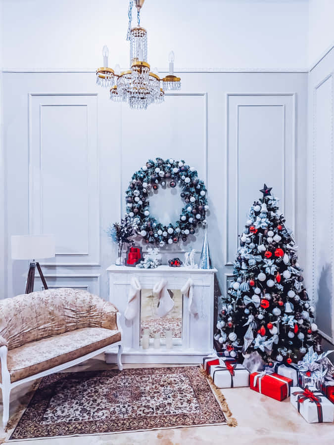 Aesthetic Christmas Tree 桌布 壁紙 — 優雅的白色房間，為聖誕節裝飾，有聖誕樹、紅色裝飾品、花環和吊燈。