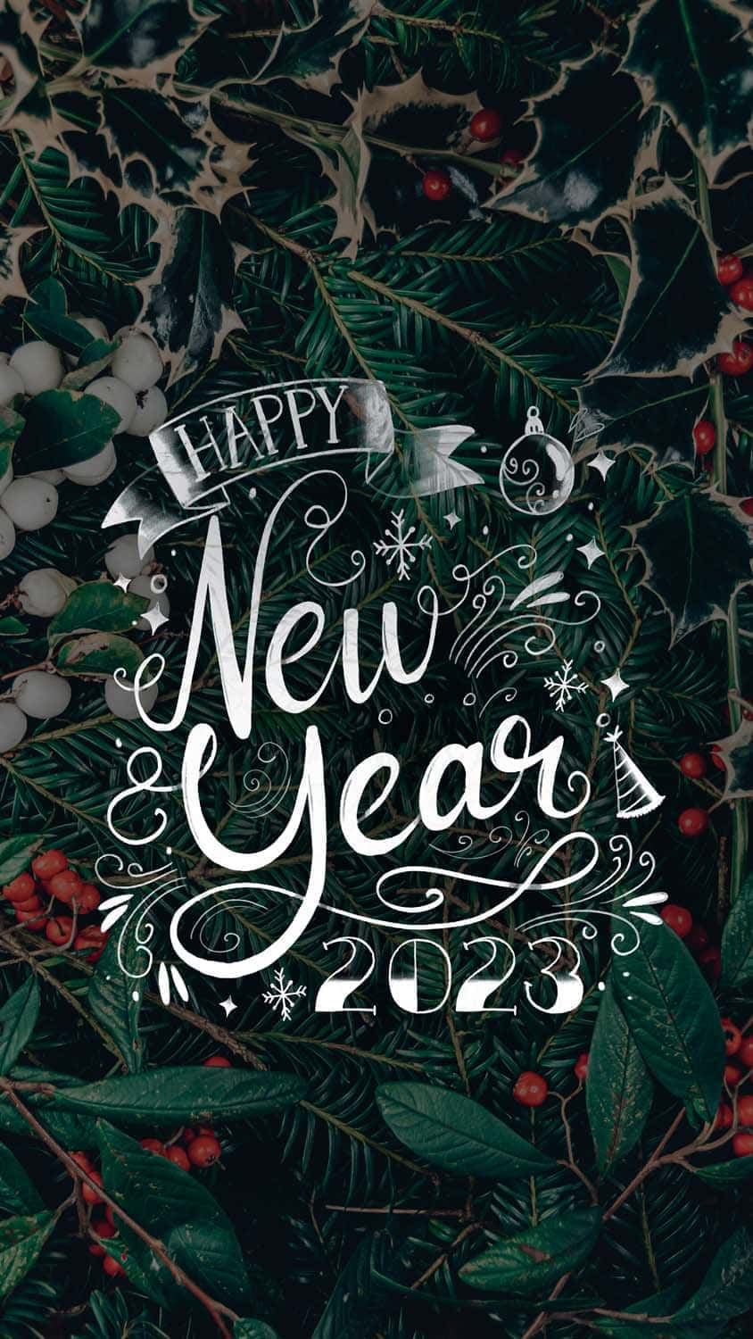 節日 桌布 壁紙 — 優雅的白色書法字體寫著「Happy New Year 2023」，覆蓋在茂密的深綠色冬青葉和紅色漿果上。