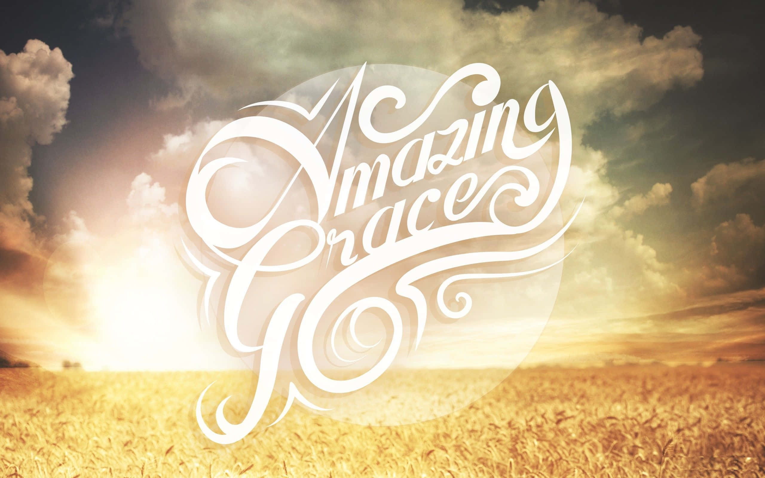 基督教 桌布 壁紙 — 優雅的白色書法拼寫出「Amazing Grace」，漂浮在日落時分的金色麥田上。
