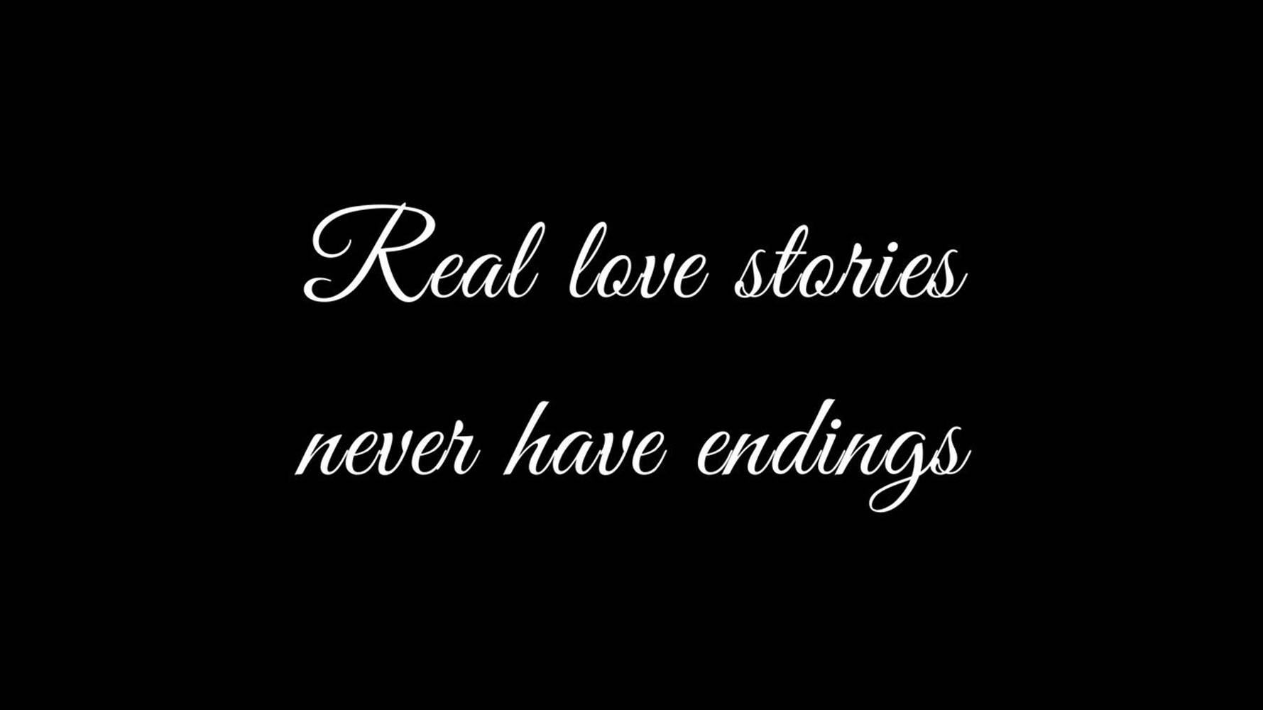 桌布 壁紙 — 優雅的白色草書文字在純黑色背景上寫著「Real love stories never have endings」。