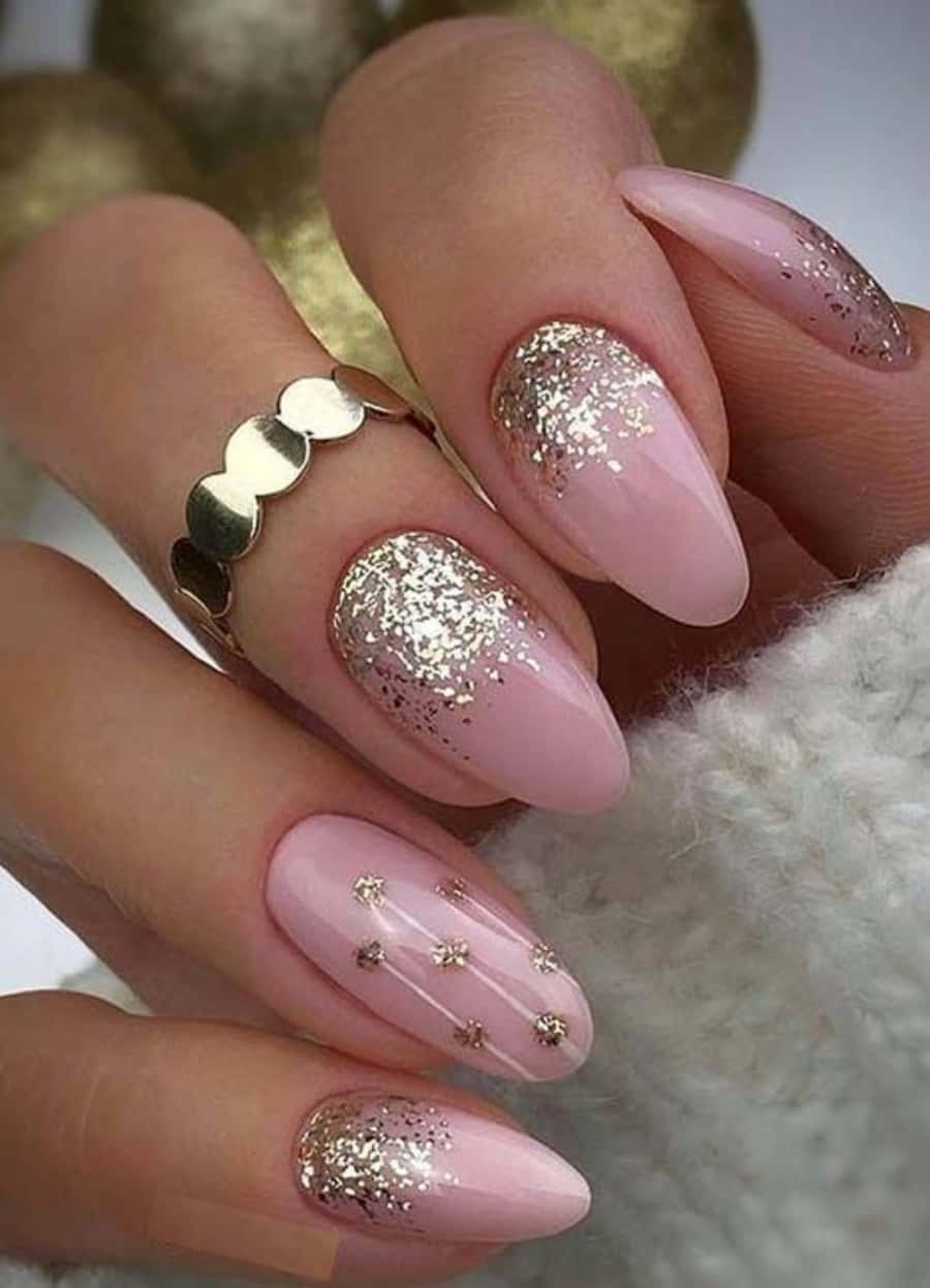 Pink Nail Art 桌布 壁紙 — 優雅的粉紅色杏仁形指甲，飾有金色亮粉和星星點綴，旁邊放著柔軟的白色針織布料。