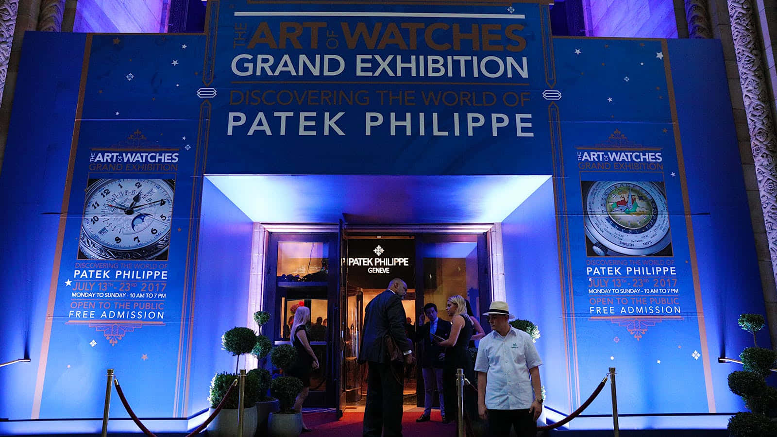 People 桌布 壁紙 — 優雅的藍色燈光入口，通往Art of Watches Grand Exhibition，展示百達翡麗，賓客在星光標誌下聚集。