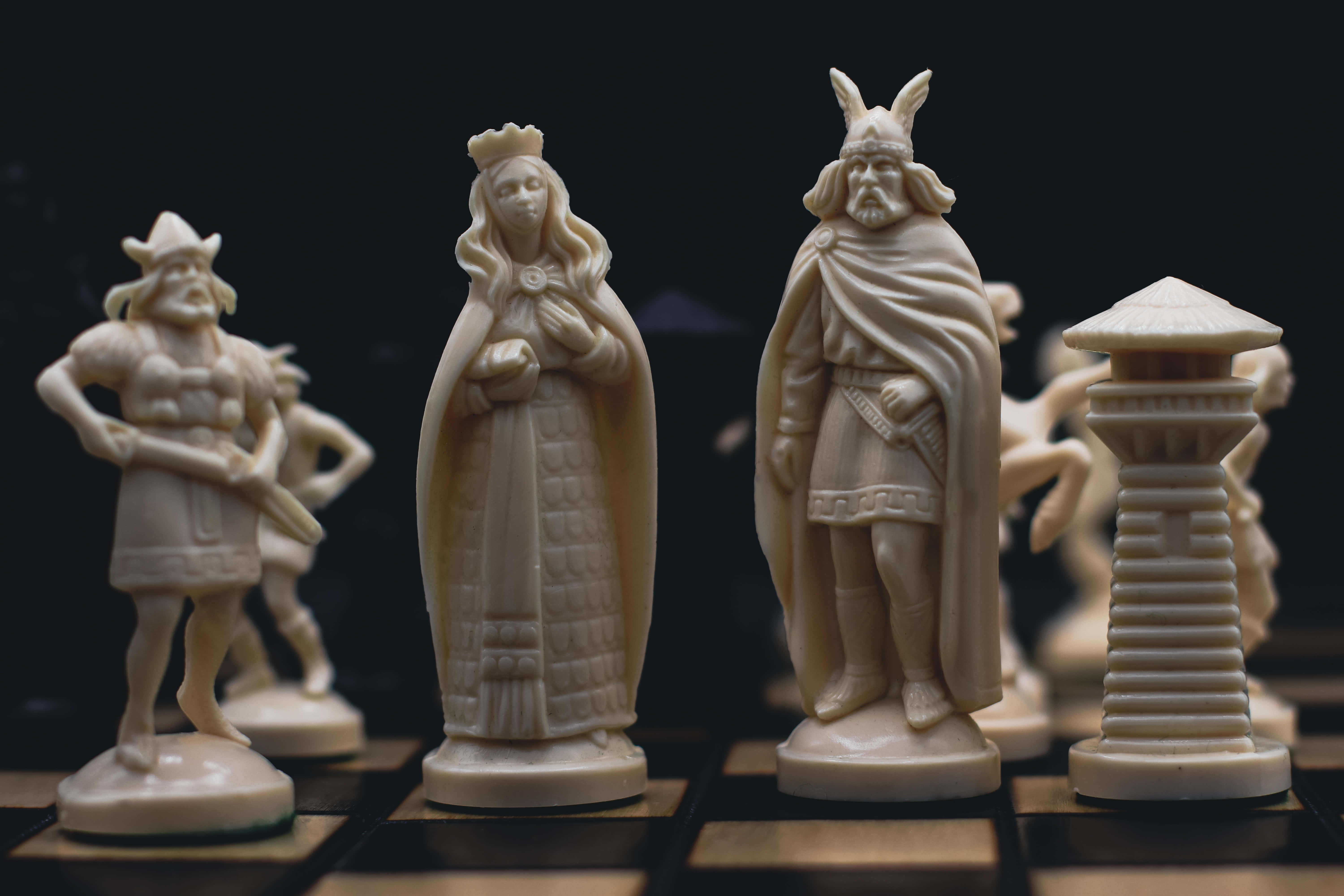 國王 桌布 壁紙 — 優雅的象牙色西洋棋棋子，中世紀戰士女王和國王站在深色棋盤上。