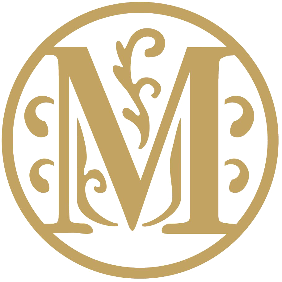 字母M 桌布 壁紙 — 優雅的金色字母M花押字，置於帶有華麗裝飾的圓形框架內，背景為黑色。