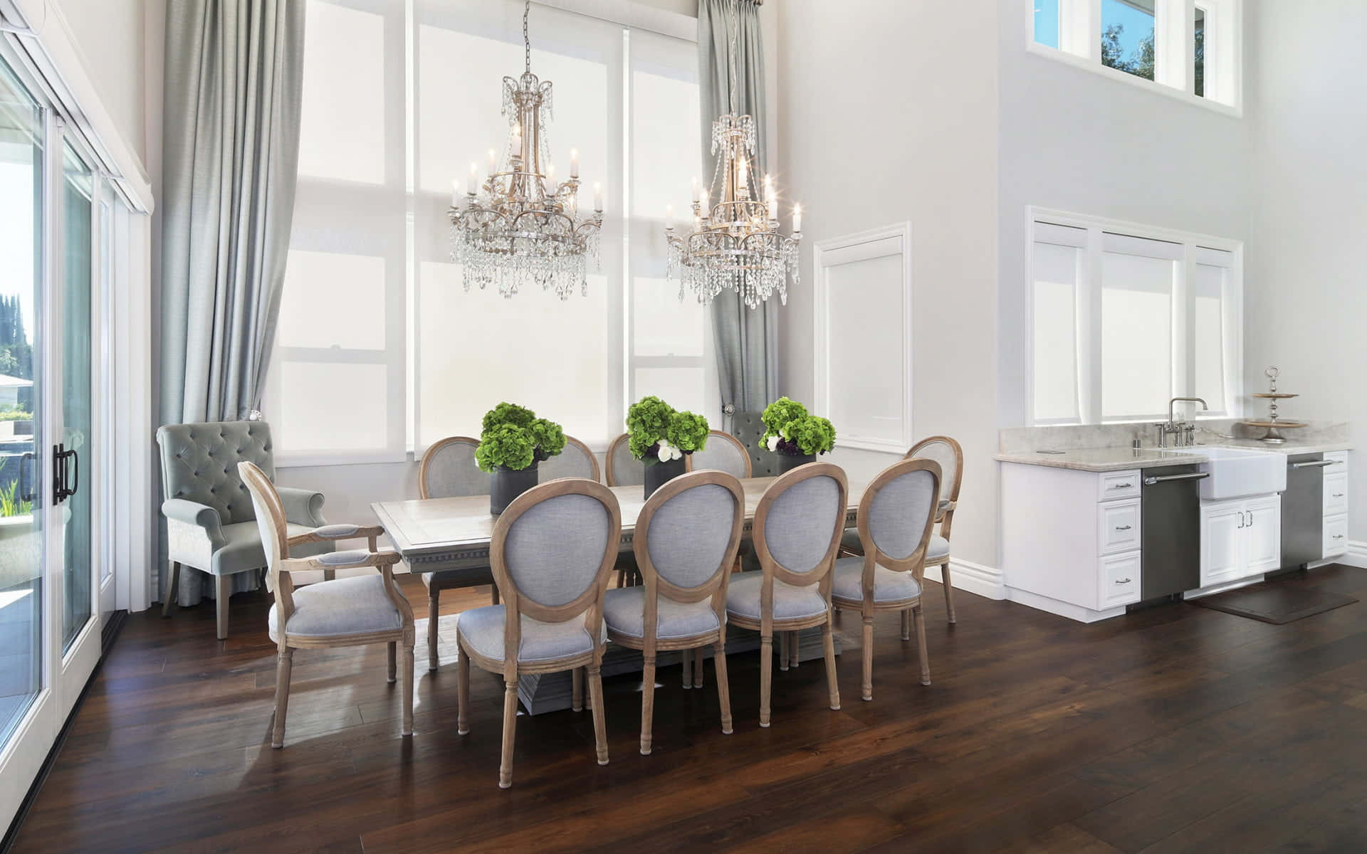 Dining Room 桌布 壁紙 — 優雅的飯廳，配有水晶吊燈、灰色軟墊椅和深色木地板，在明亮的自然光下。
