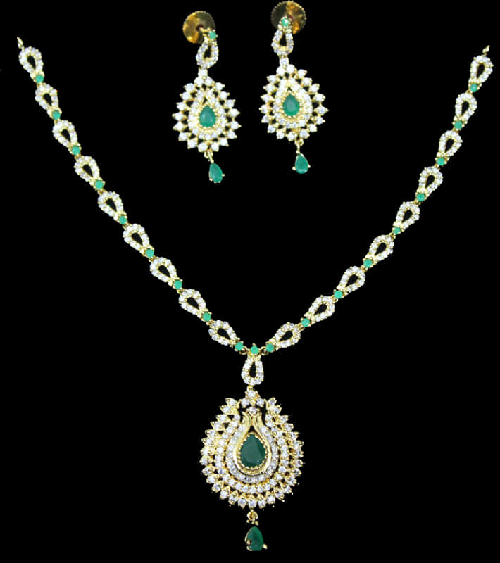 Indian Jewellery 桌布 壁紙 — 優雅的黃金珠寶套裝，帶有祖母綠和鑽石點綴，在黑色背景上展示。