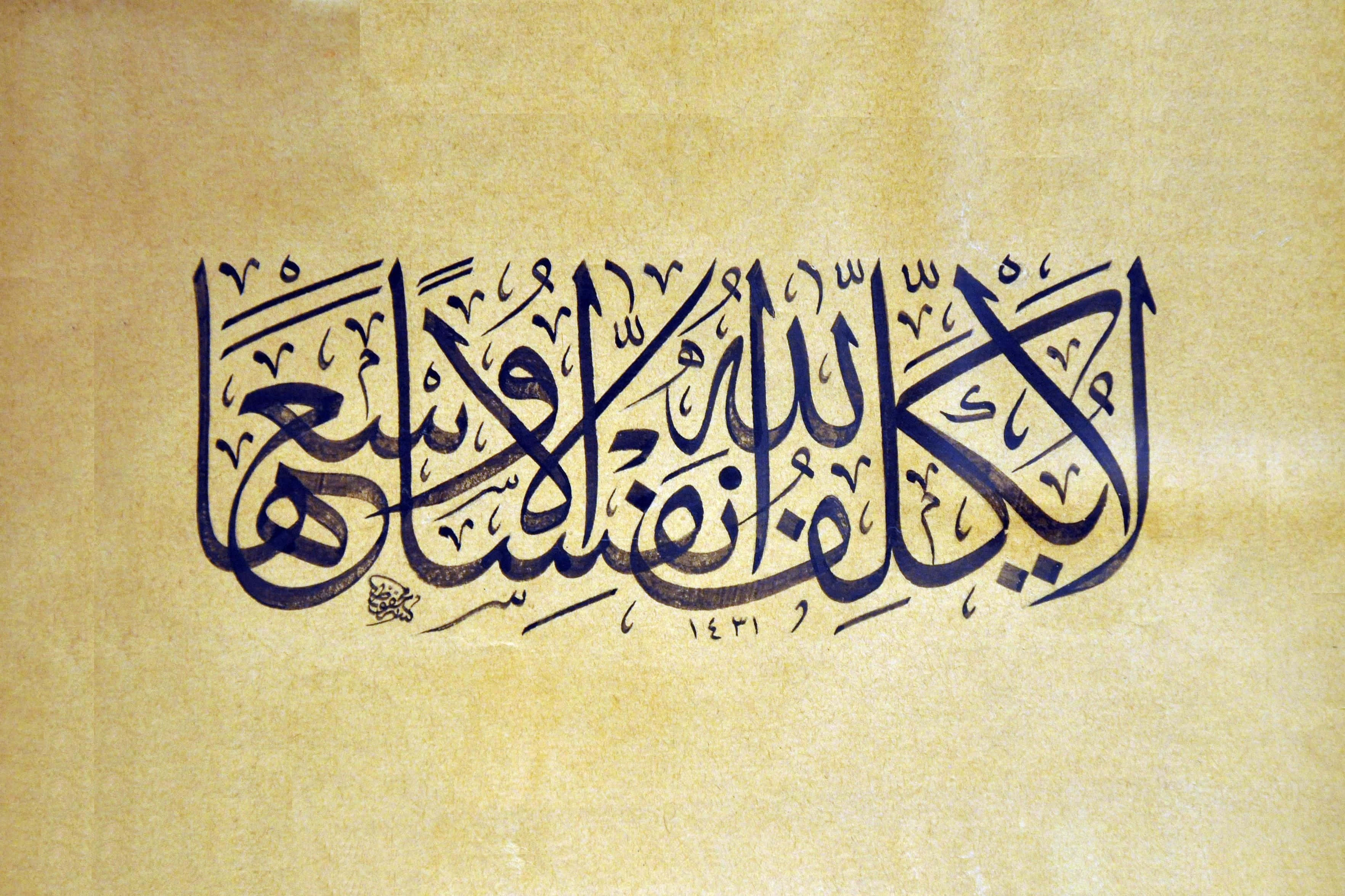 arabic 桌布 壁紙 — 優雅的黑色阿拉伯書法在帶有細微紋理和溫暖米色背景的舊羊皮紙上流動。