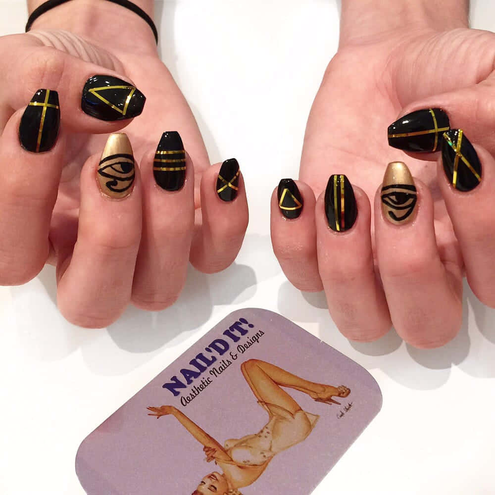 Nail 桌布 壁紙 — 優雅的黑金幾何指甲藝術，以眼睛圖案點綴雙手，搭配白色背景上的復古海報卡。