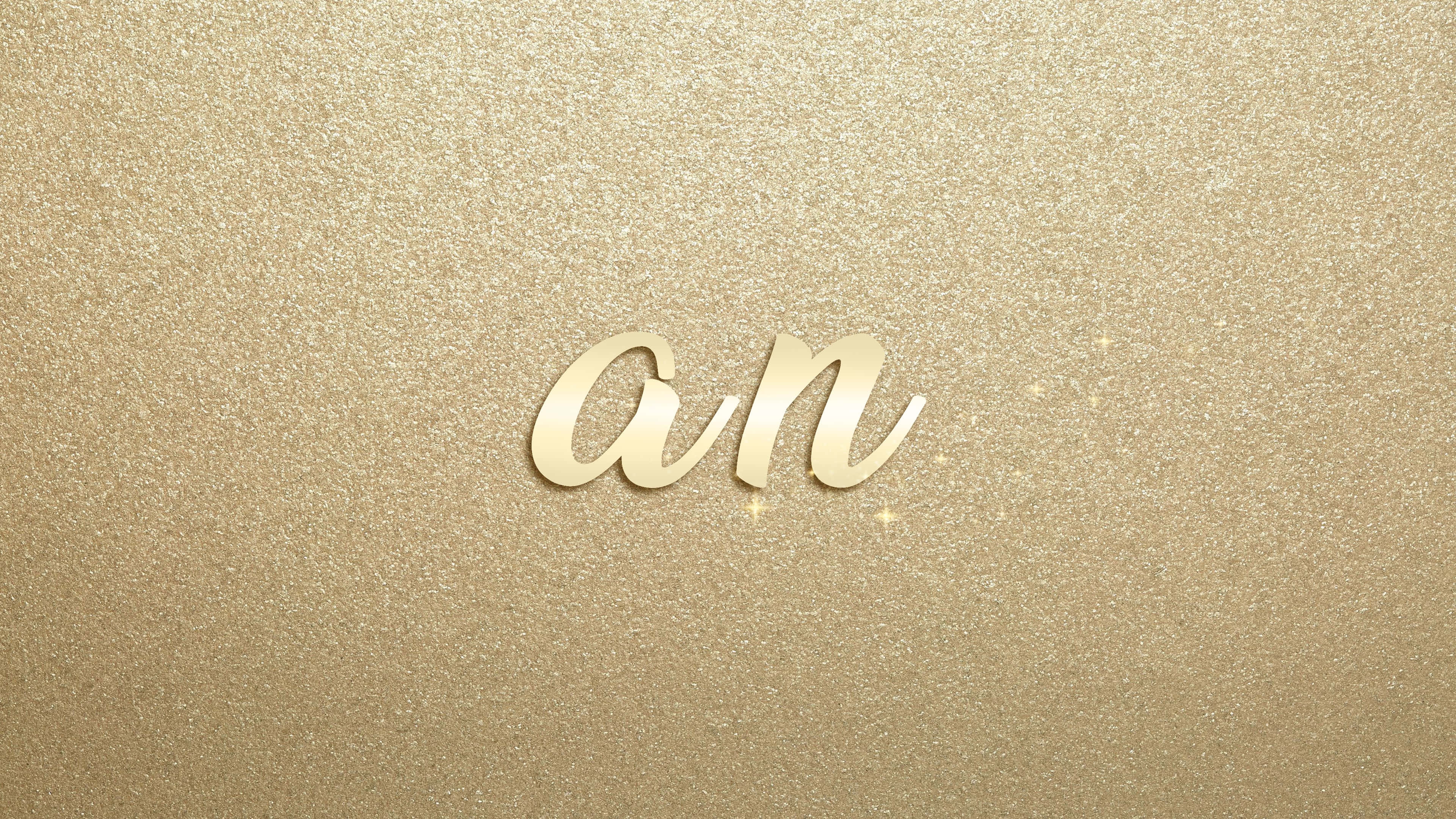Typography 桌布 壁紙 — 優雅草書字母 an 漂浮在閃爍金色亮粉背景上，帶有閃亮高光。