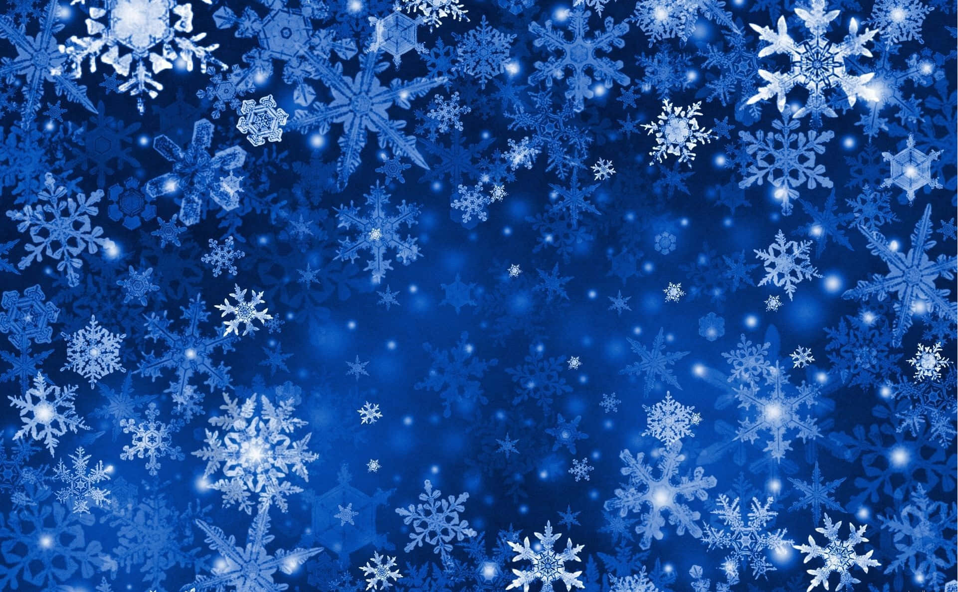 Winter Blues 桌布 壁紙 — 充滿各種精緻設計的發光白色雪花在神奇冬日場景中飄浮的鮮豔藍色背景。