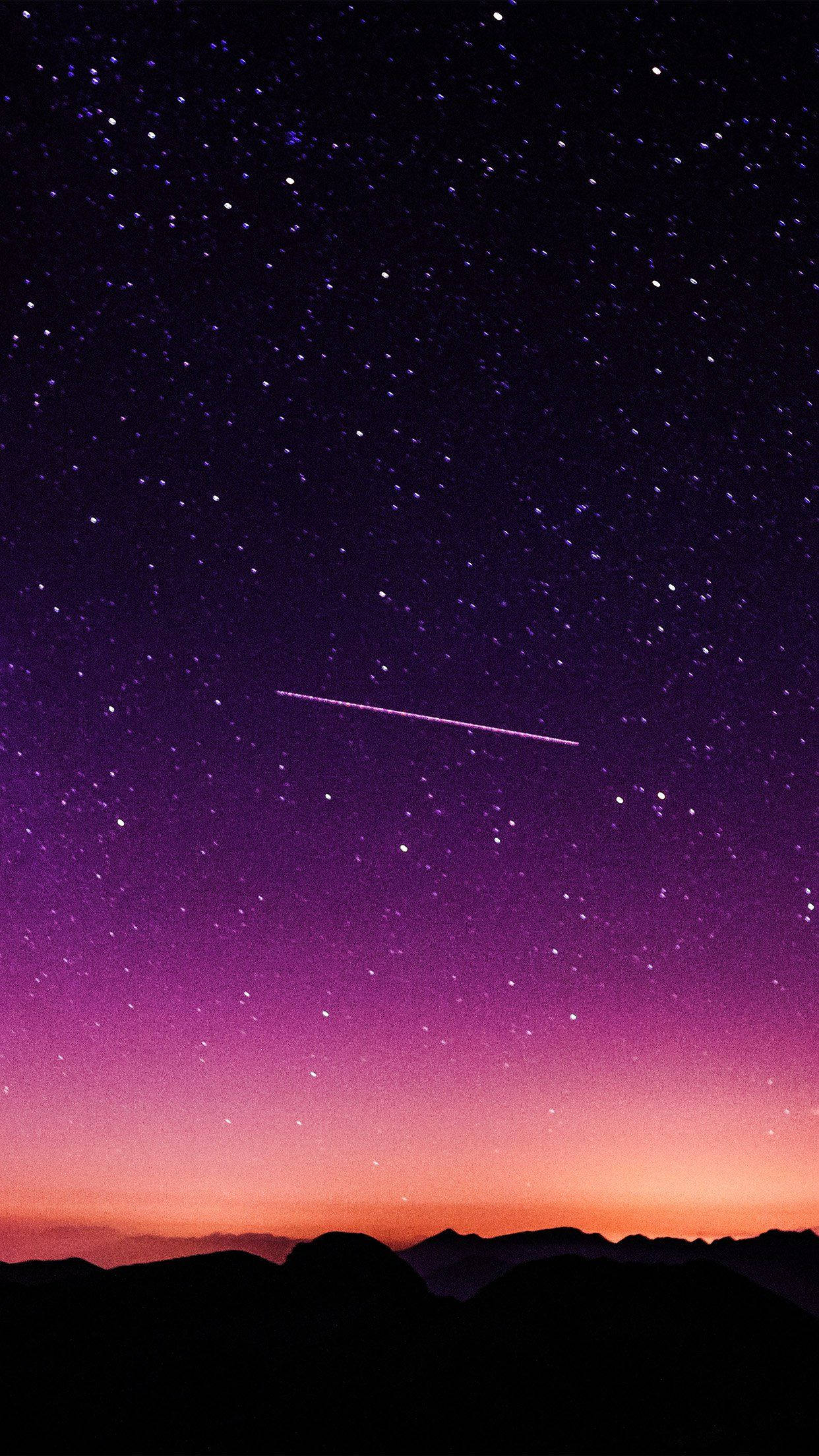 Shooting Star 桌布 壁紙 — 充滿星星的鮮豔紫色和橙色暮色天空，一顆發光的流星劃過黑暗的山脈輪廓。