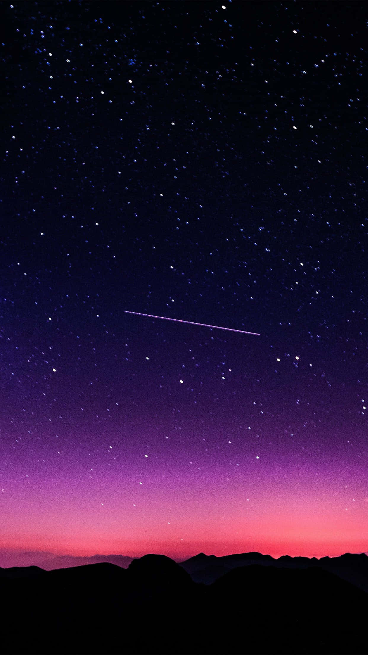 雲朵 桌布 壁紙 — 充滿星星的鮮豔紫色和粉紅色暮色天空，一顆發光的流星劃過黑暗的山脈輪廓。