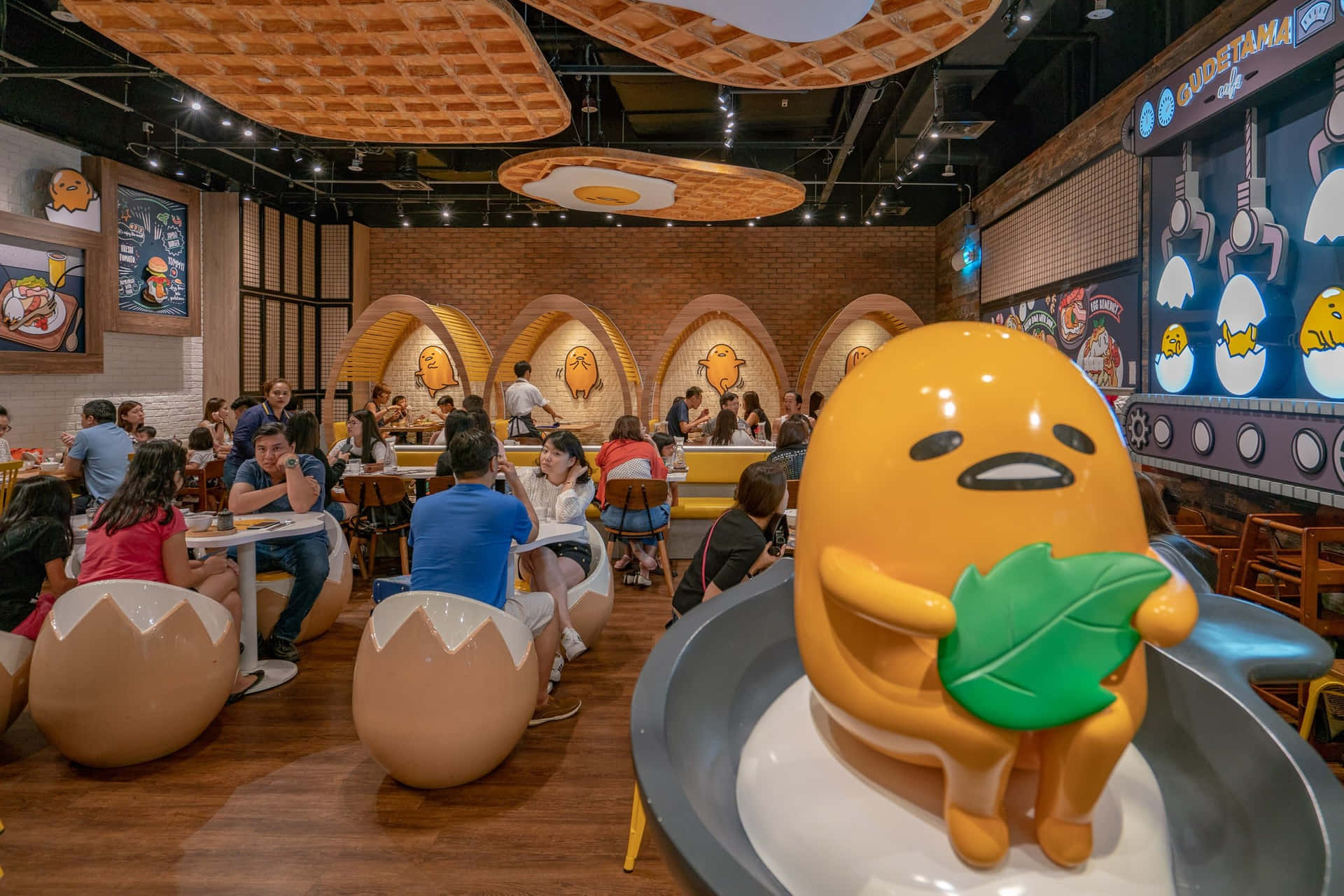 Gudetama 主題餐廳，有顧客和蛋形座位。 — 蛋黃哥 壁紙