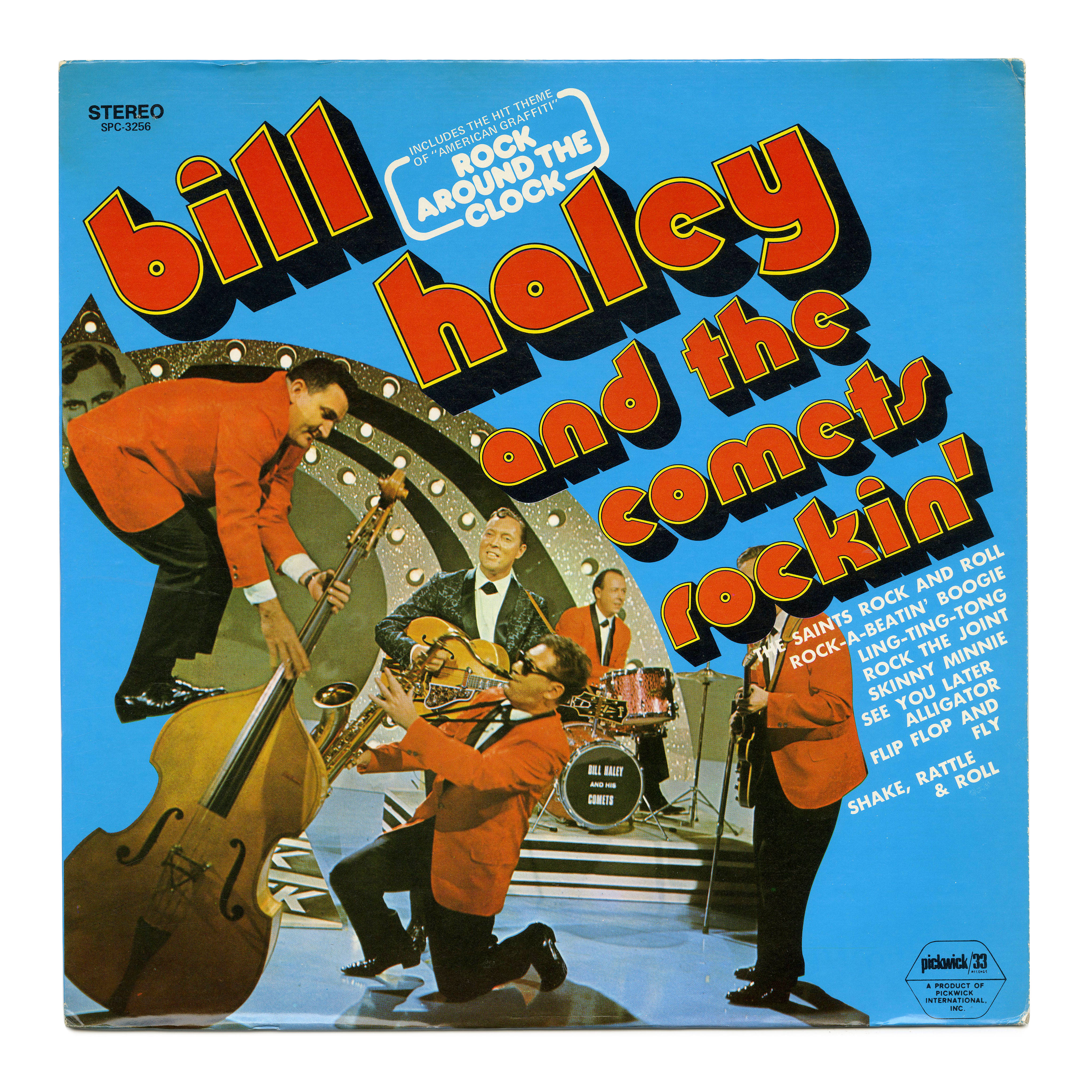 band 桌布 壁紙 — 充滿活力的1950年代搖滾樂專輯封面，Bill Haley and the Comets 穿著大膽的紅色西裝，在明亮的藍色背景前充滿活力地表演。